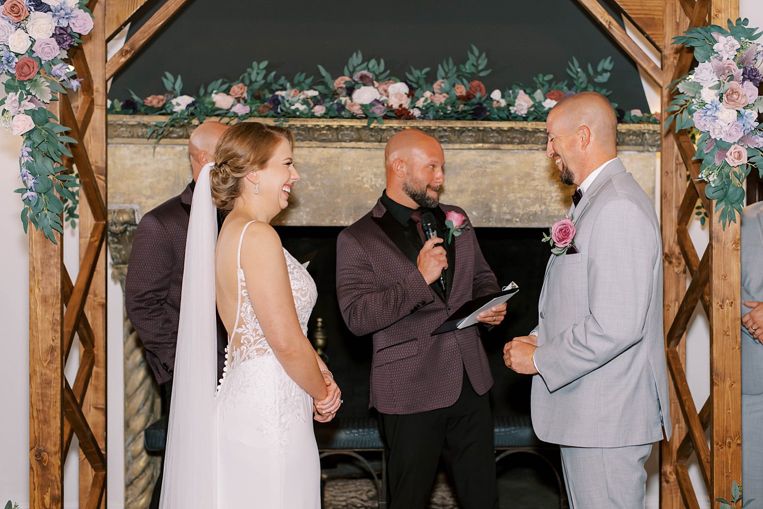 officiant in plum suit jacket reads during ceremony at Bella Cosa Lakeside