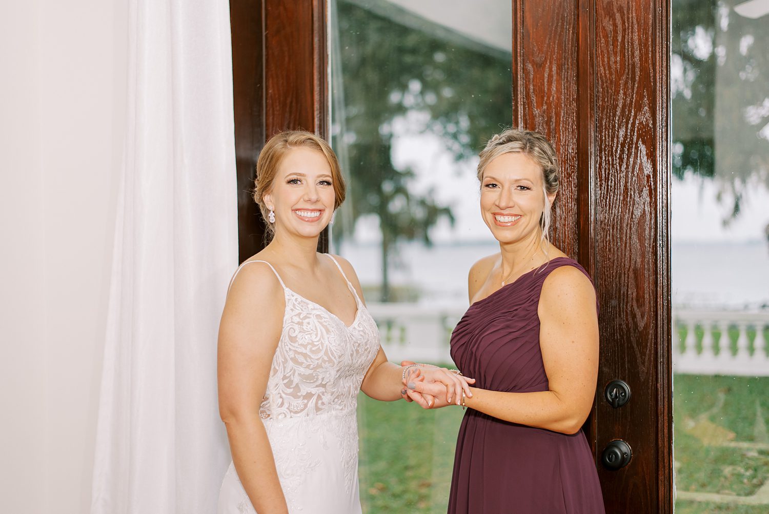 bridesmaid helps bride with jewelry before FL wedding