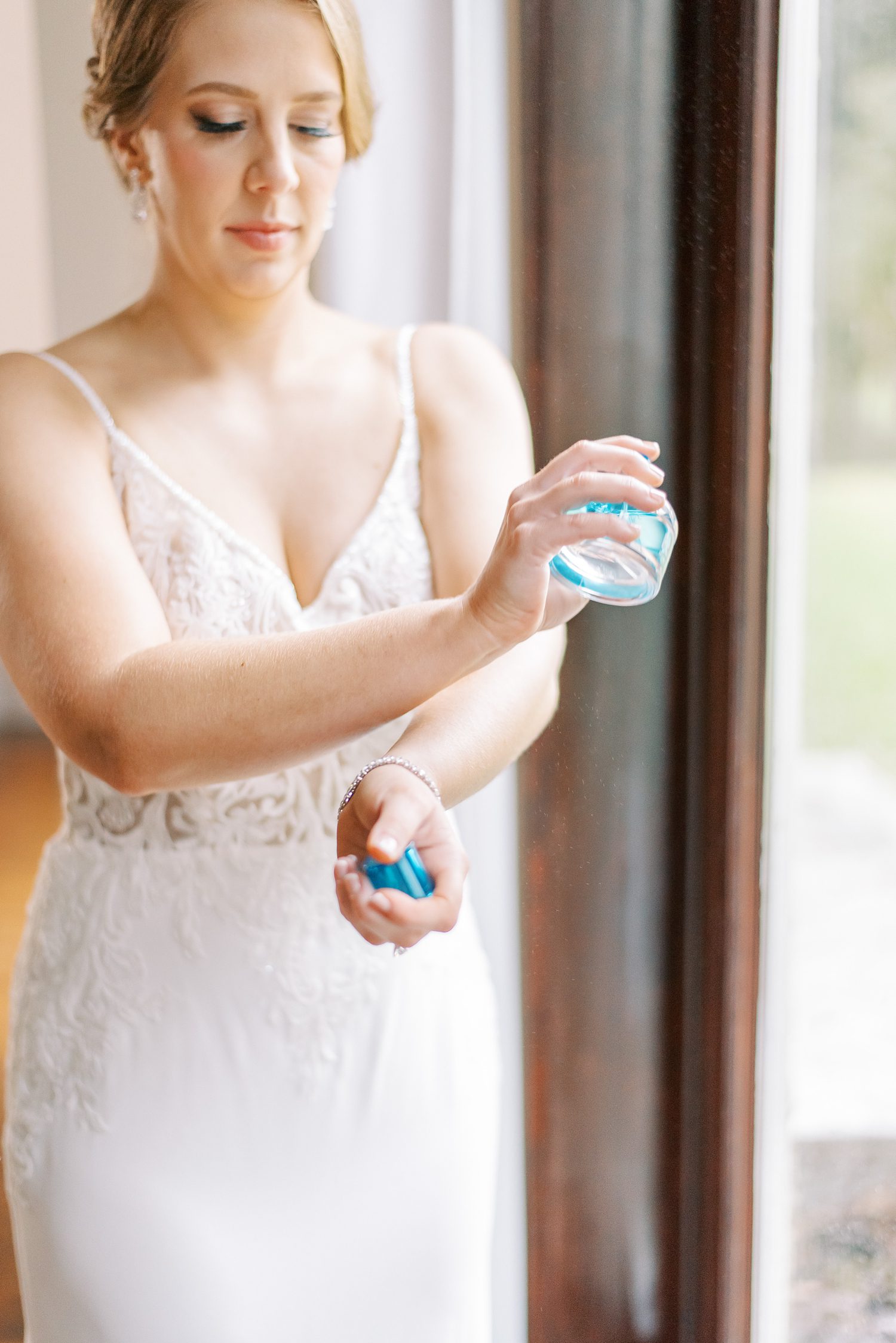 bride rubs perfume on her wrists