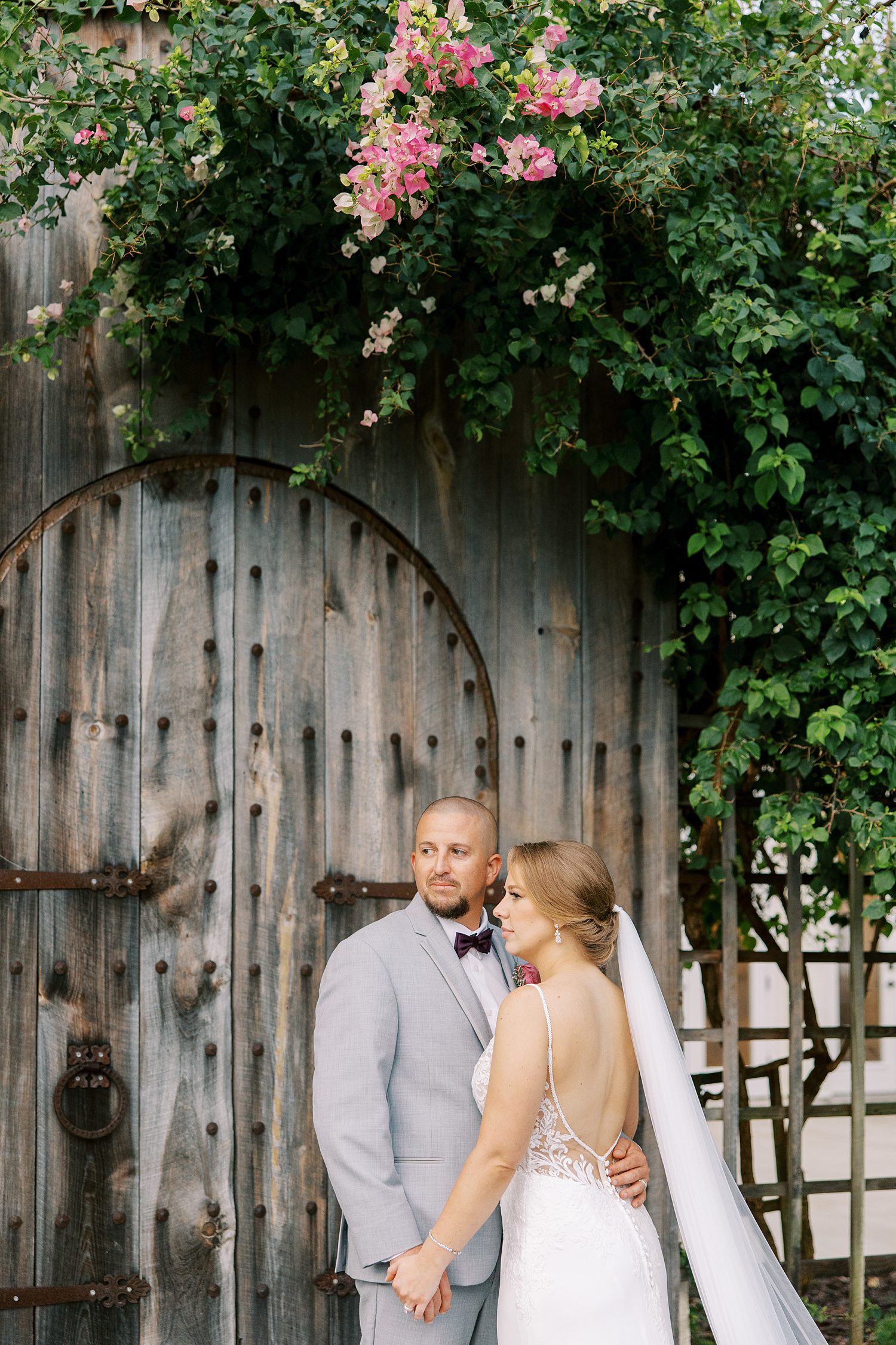 bride and groom hug by wooden doorway at Bella Cosa Lakeside