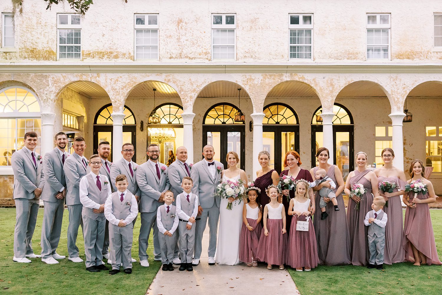 bride and groom pose with wedding party outside Bella Cosa Lakeside