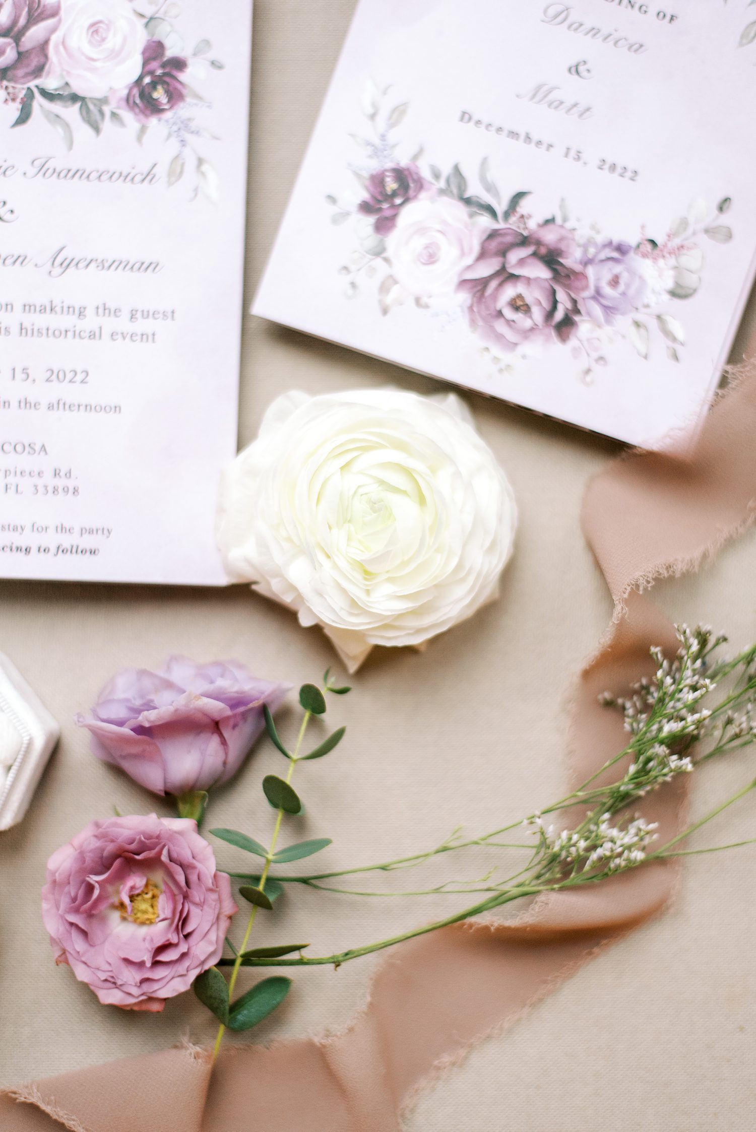white rose lays between stationery for Bella Cosa Lakeside wedding
