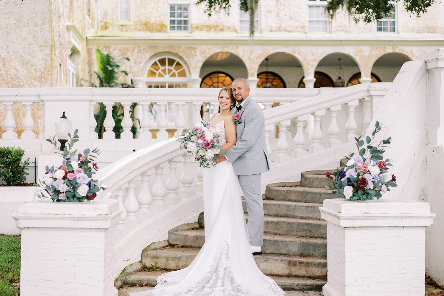 bride and groom stand on steps at Bella Cosa Lakeside