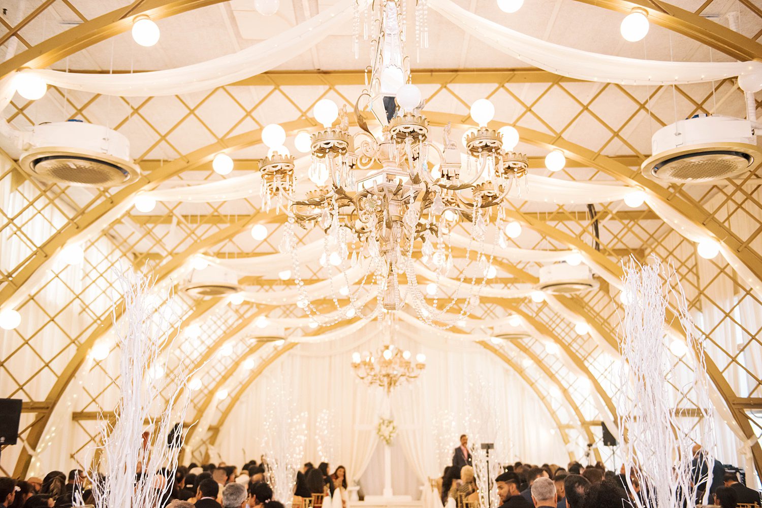 ceremony space inside Kapok Special Events under gold chandelier