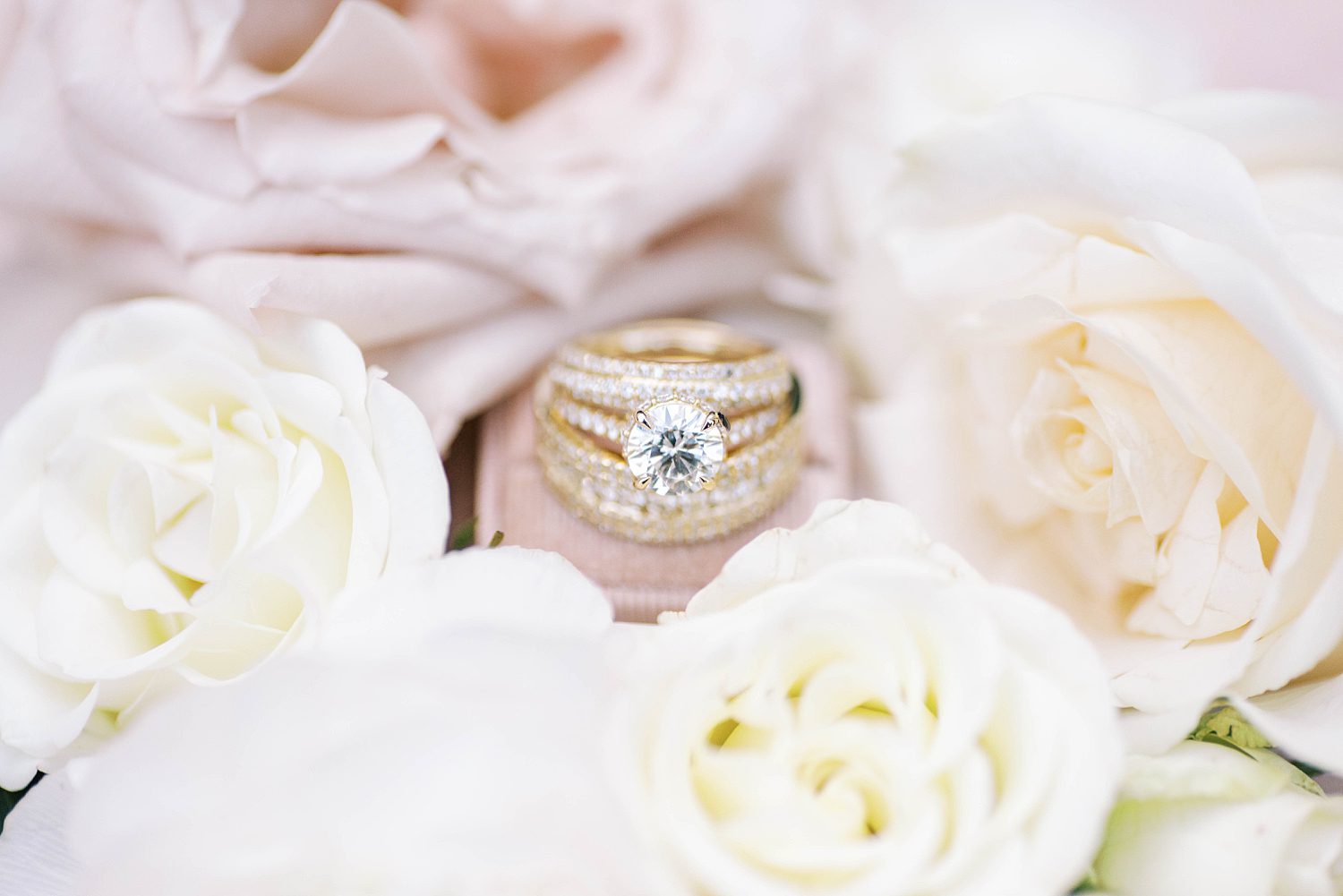gold rings stacked among ivory flowers