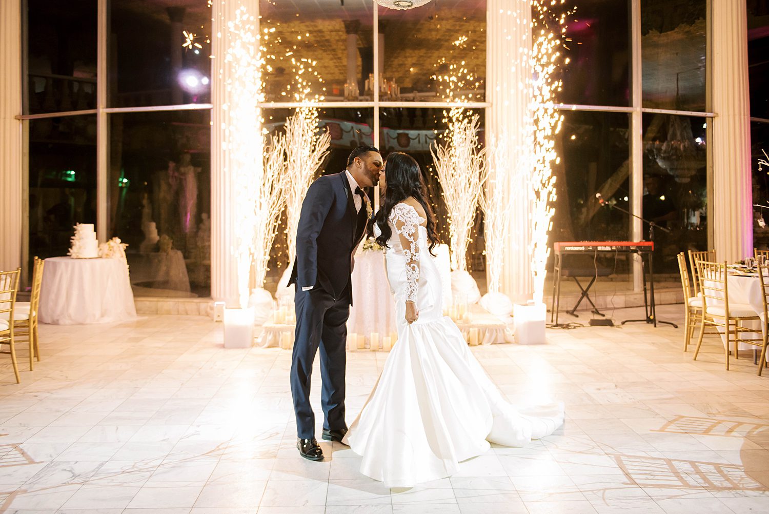 bride and groom kiss by sparklers at sweetheart table