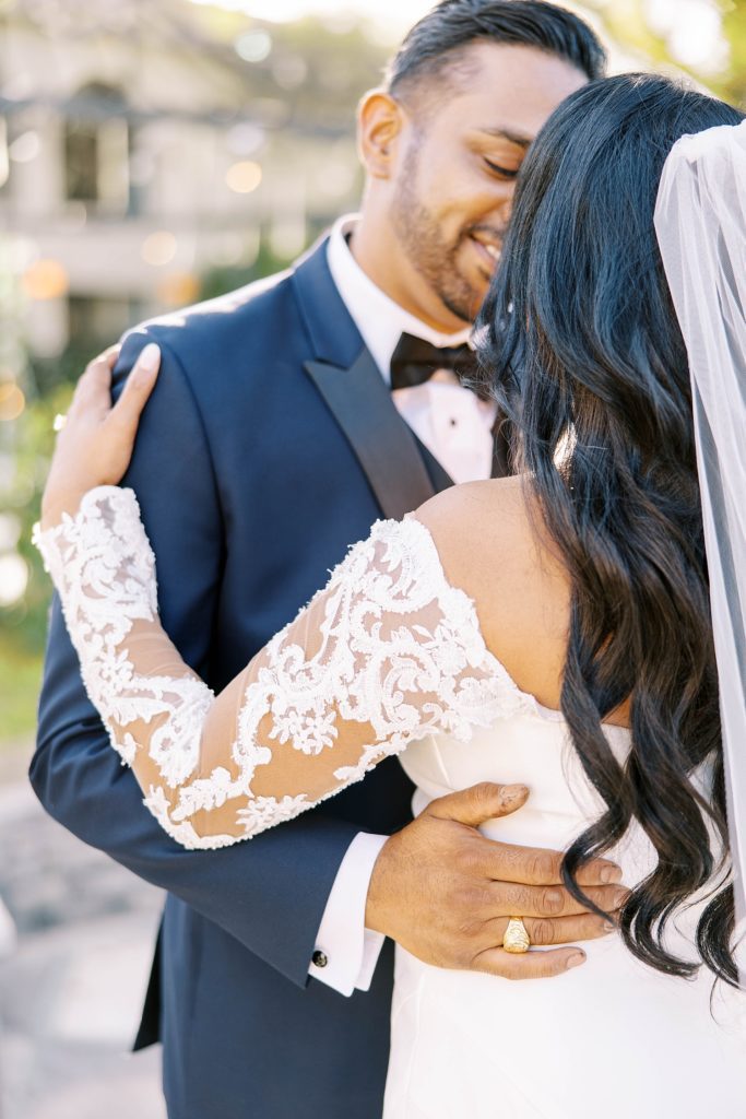 bride holds groom's shoulder in blue tux