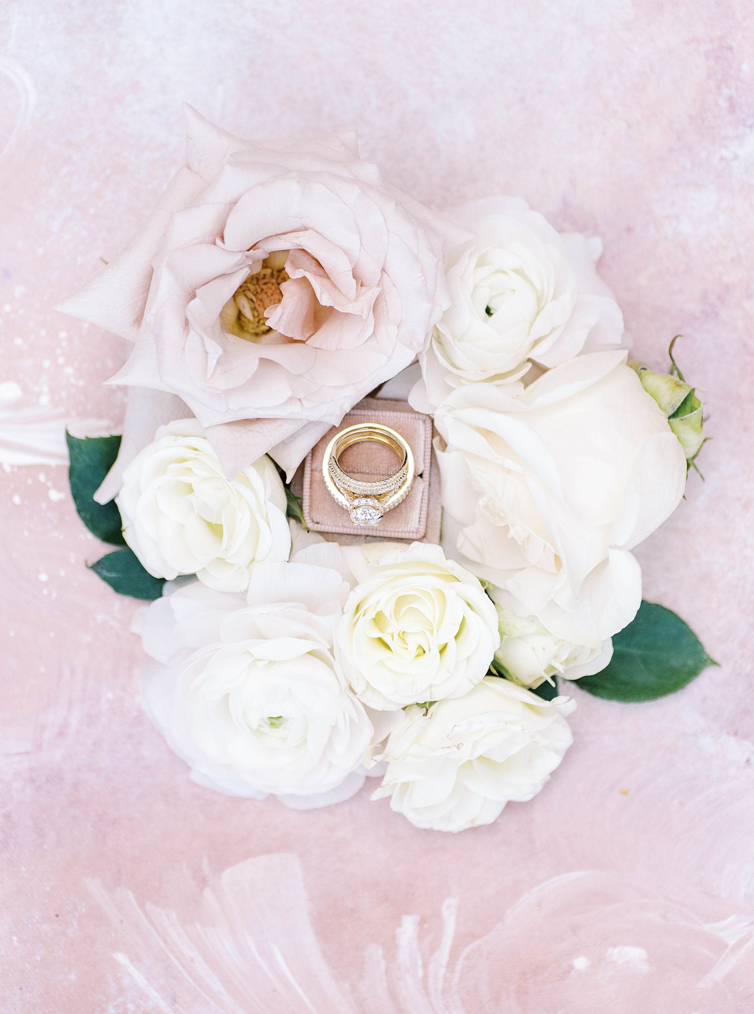 wedding rings sit in circle of flowers