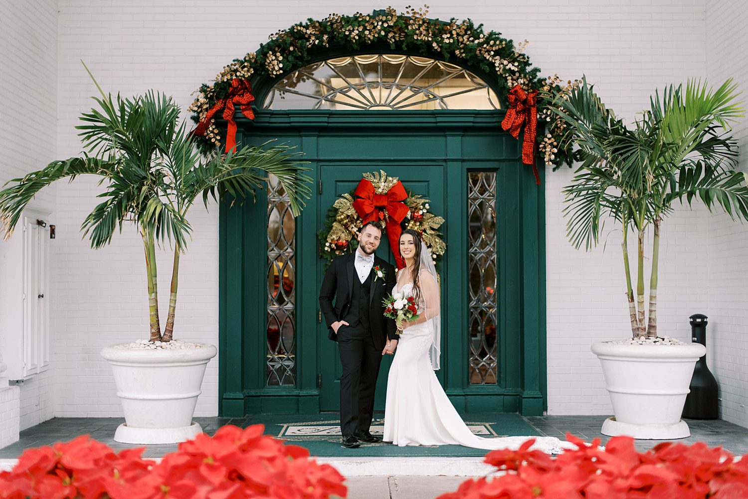 bride and groom hug against green doorway at Palma Ceia Country Club