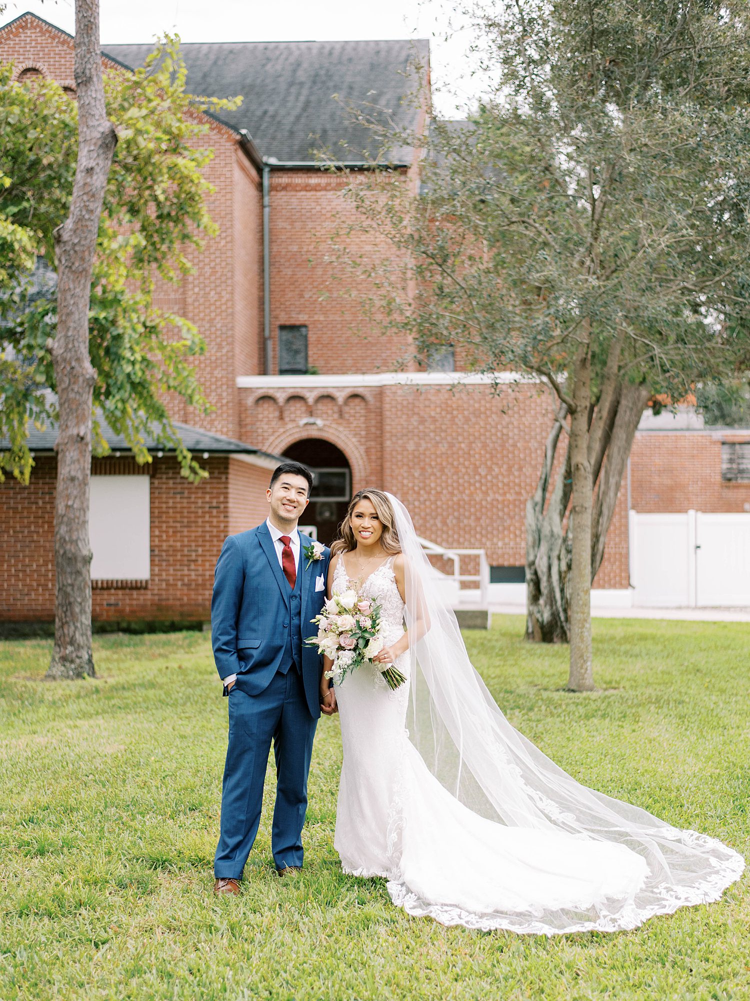 newlyweds pose on lawn of Higgins Hall in Tampa FL