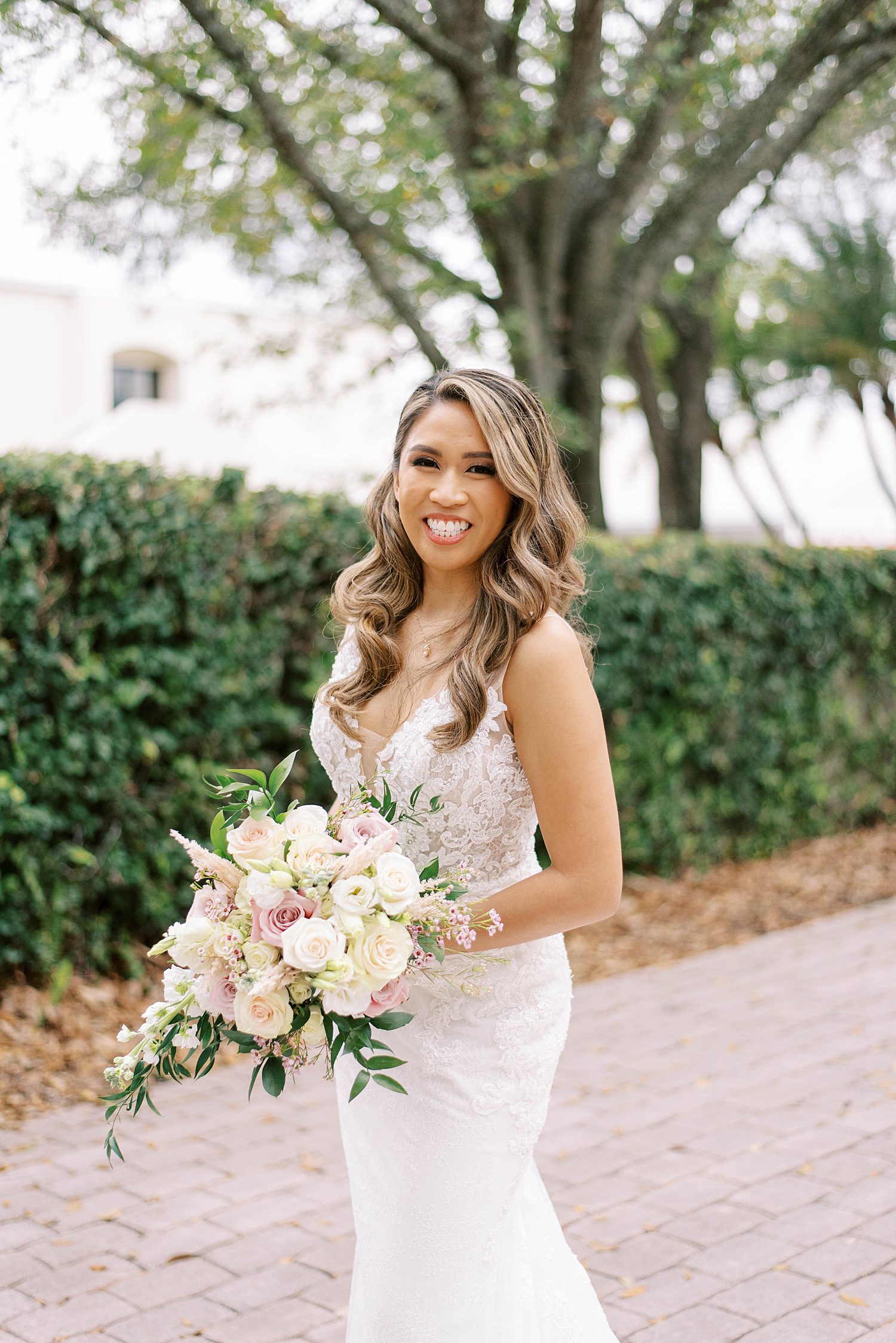 bride holds bouquet of pink and ivory roses in Tampa FL