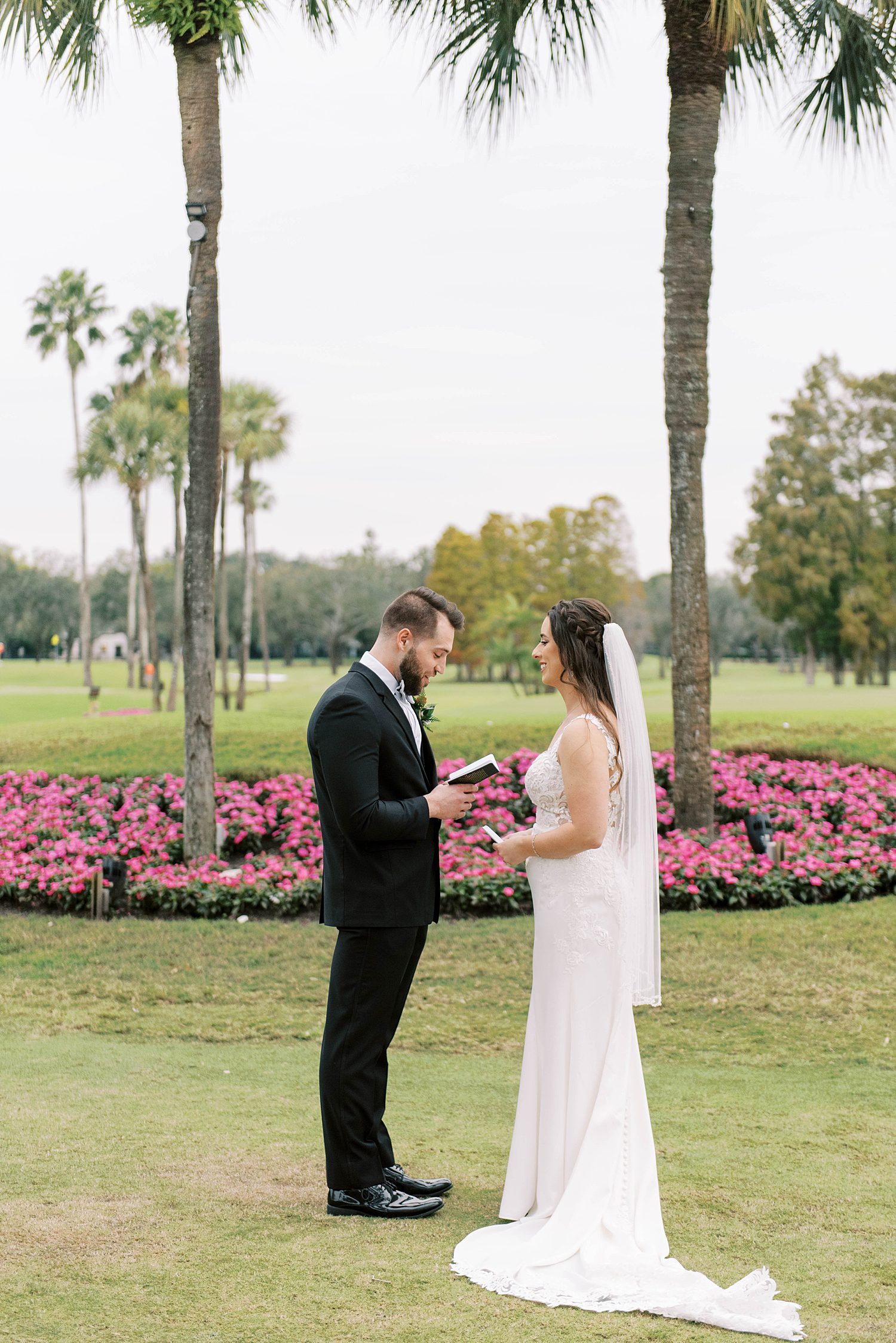 groom reads bride vows during first look on lawn at Palma Ceia Country Club
