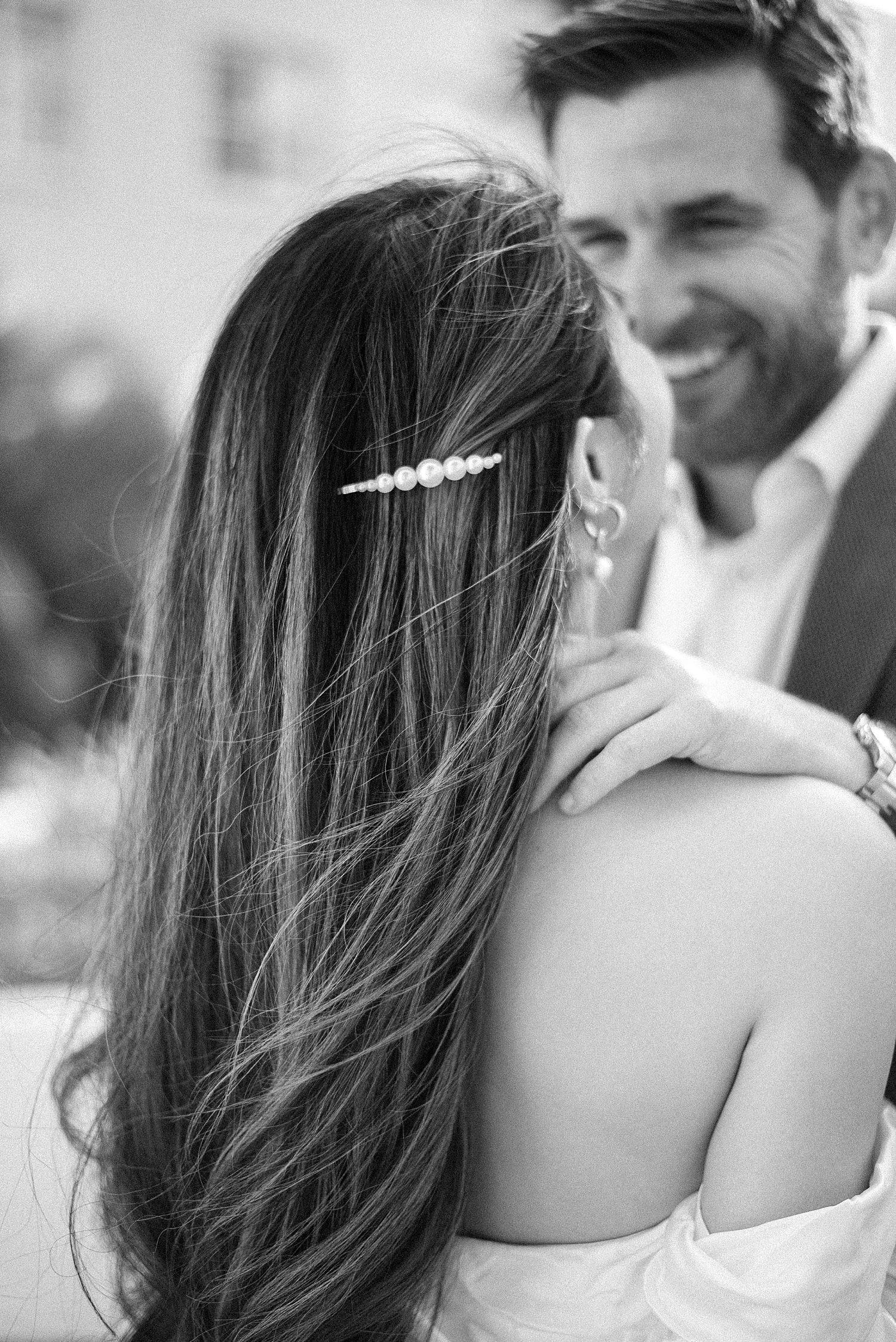 woman's hair blows in the wind with diamond clip at top 