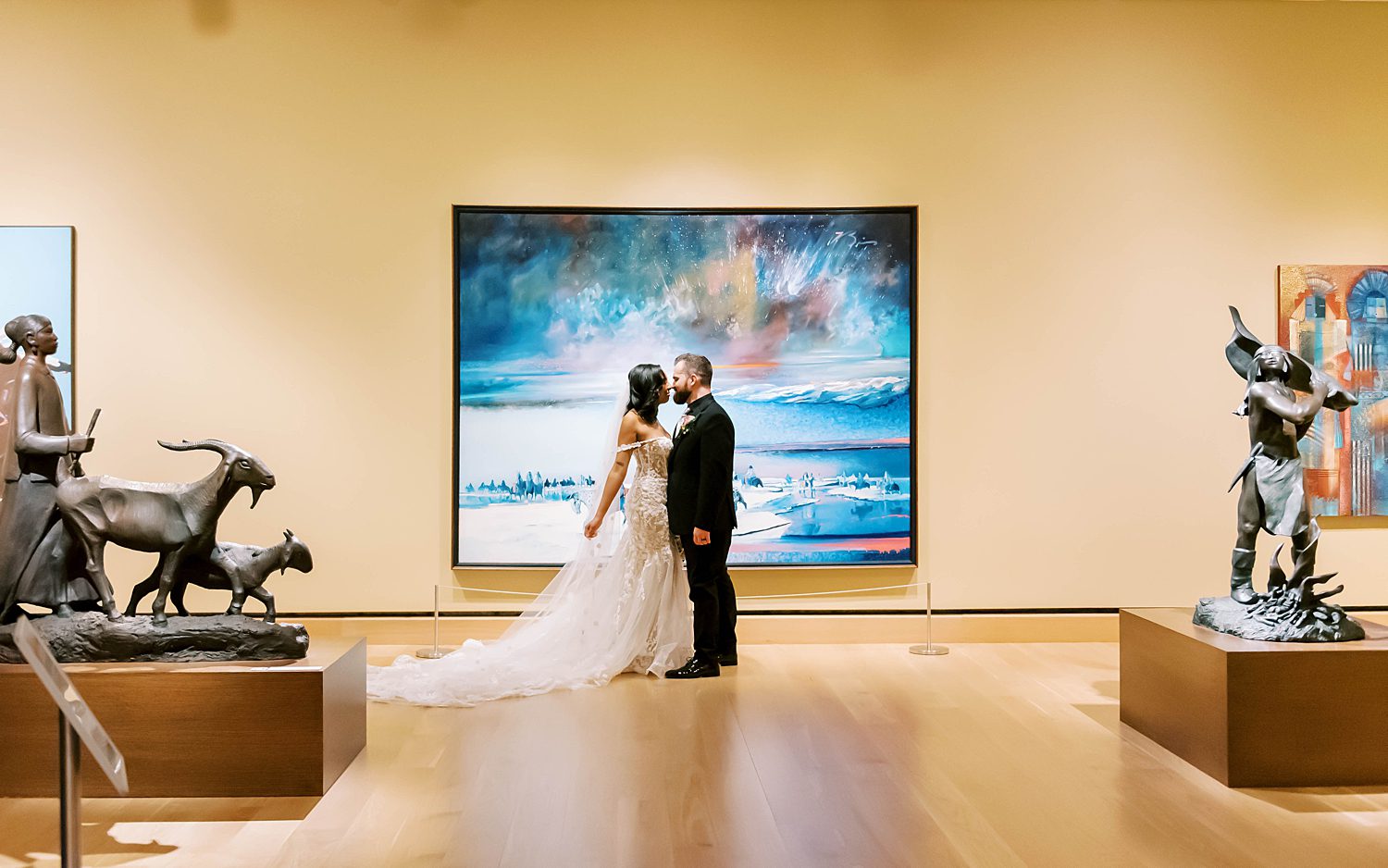 newlyweds kiss by blue painting in gallery of The James Museum