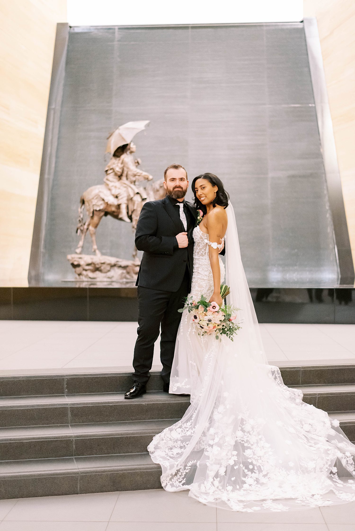 newlyweds pose near sculpture at The James Museum
