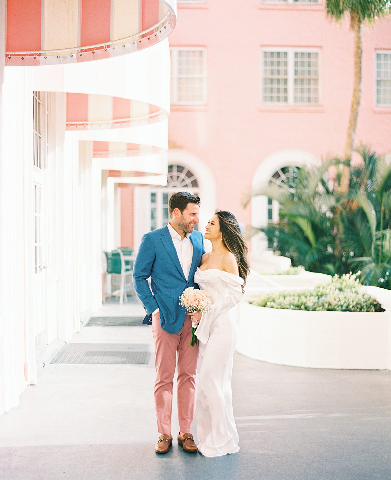 bride and groom stand in front of Don Cesar Hotel in St. Pete Beach