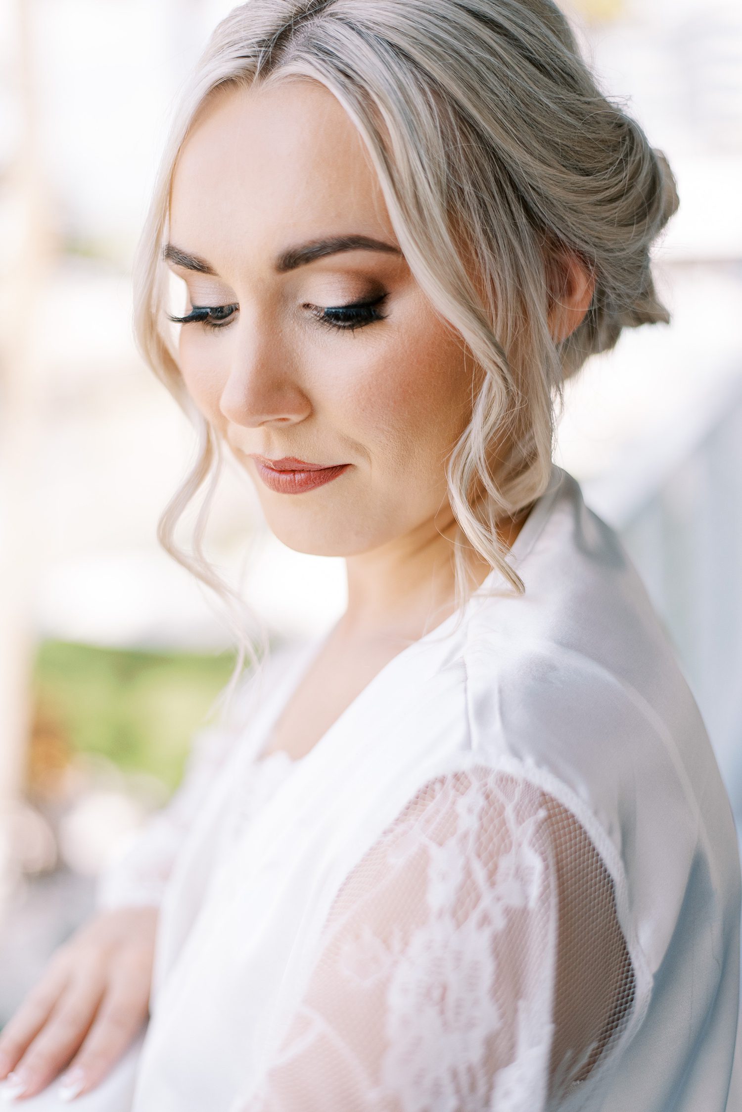 blonde woman purses lips and looks over shoulder in white lace sleeve robe