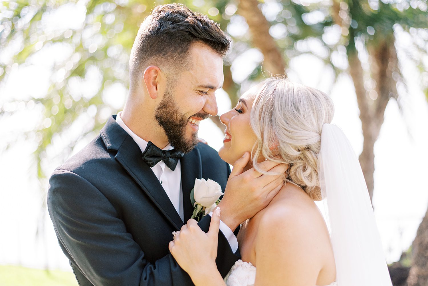 bride and groom lean together laughing while groom holds bride's neck