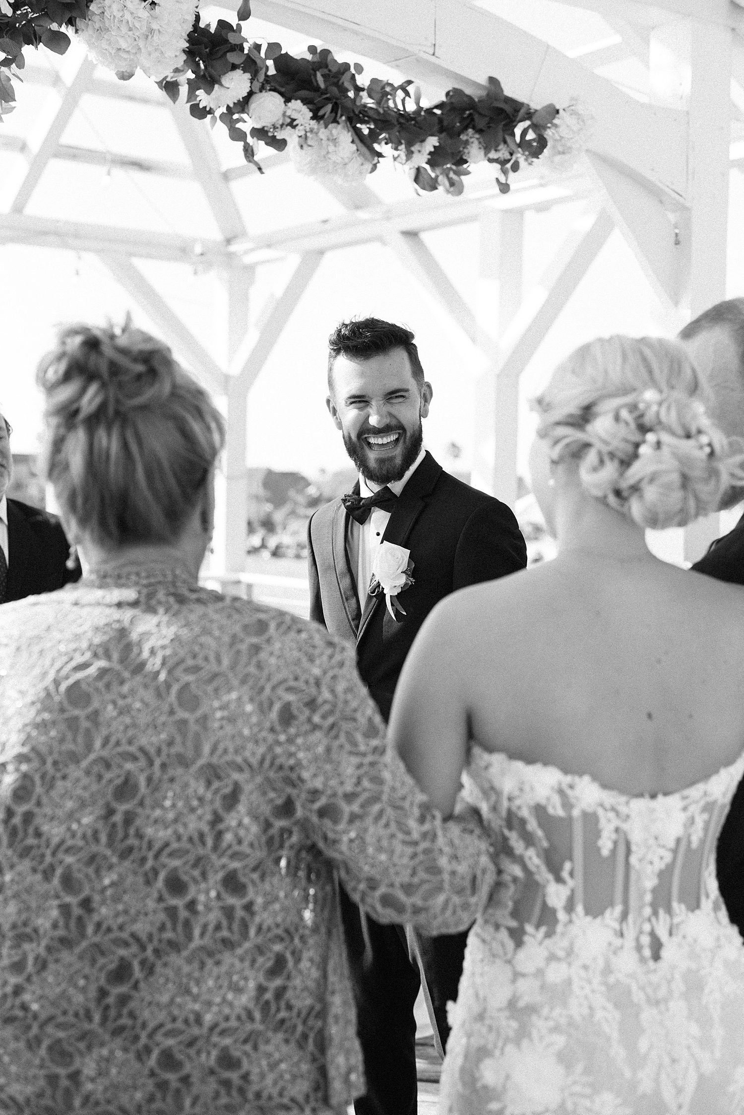 groom turns to look at bride walking down aisle with mother at The Godfrey