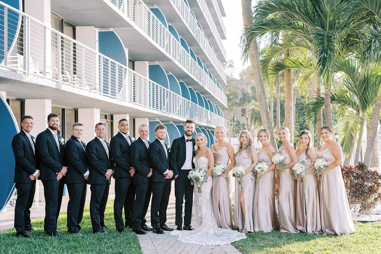 bride and groom stand with wedding party outside The Godfrey Hotel