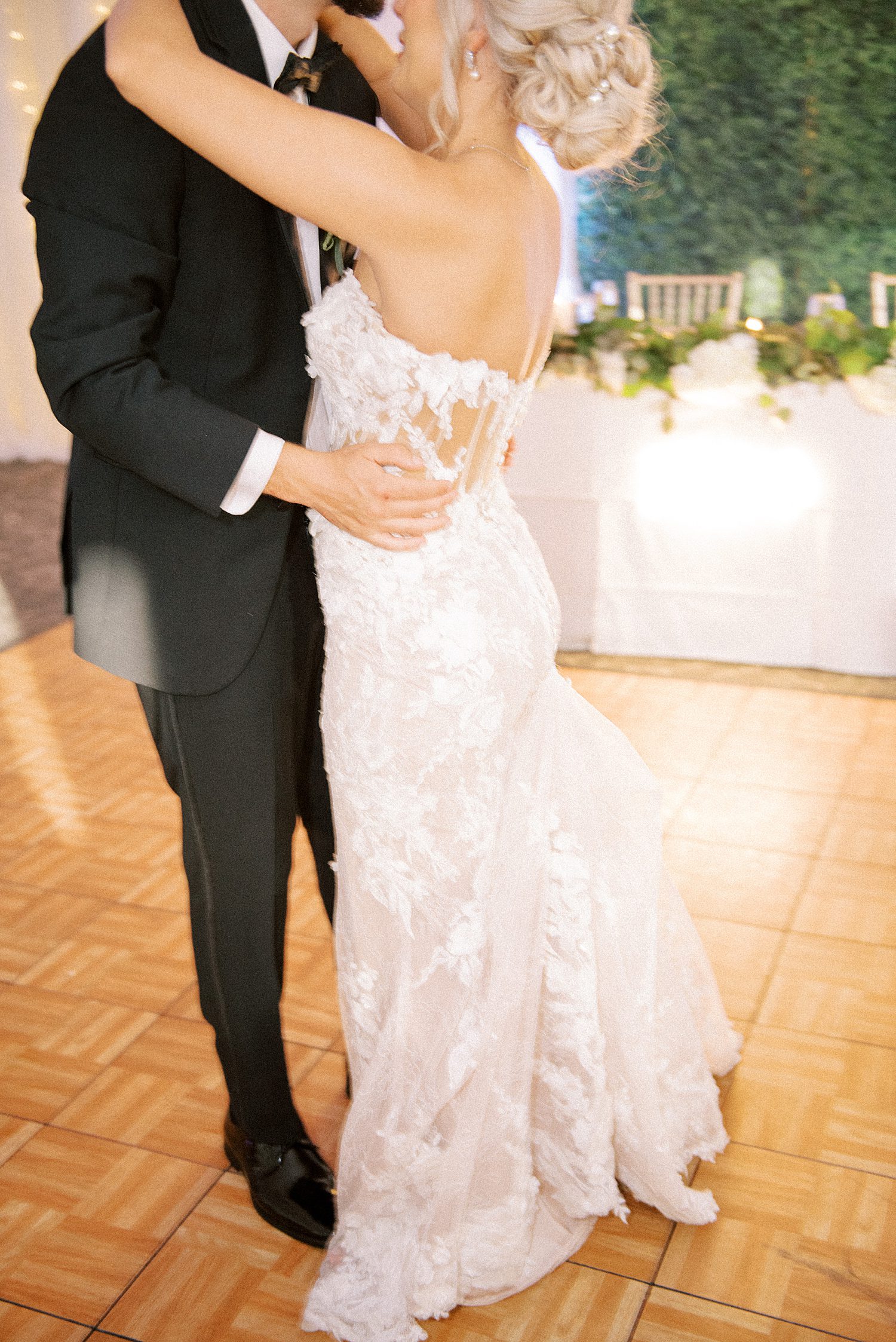 groom hugs bride to him during first dance during the Godfrey wedding reception