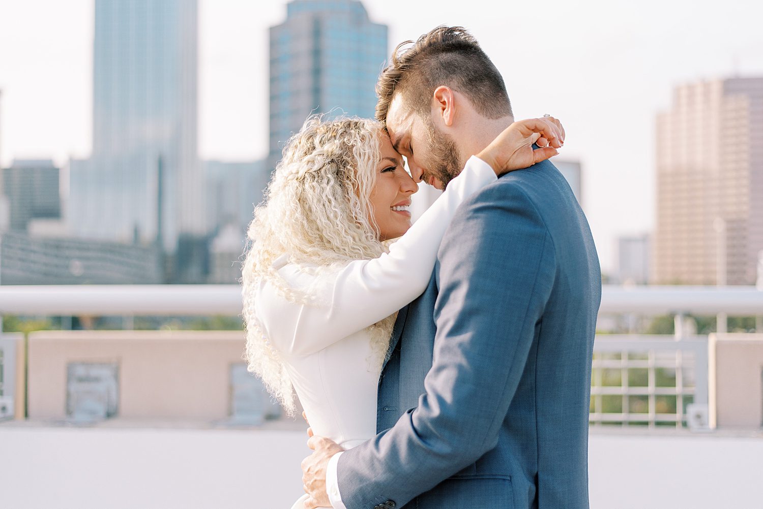 engaged couple hugs on downtown Tampa rooftop leaning heads together