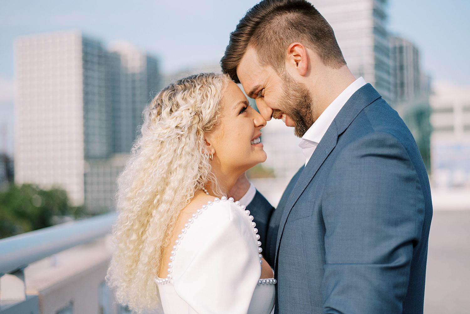 engaged couple leans heads together during downtown Tampa rooftop engagement session
