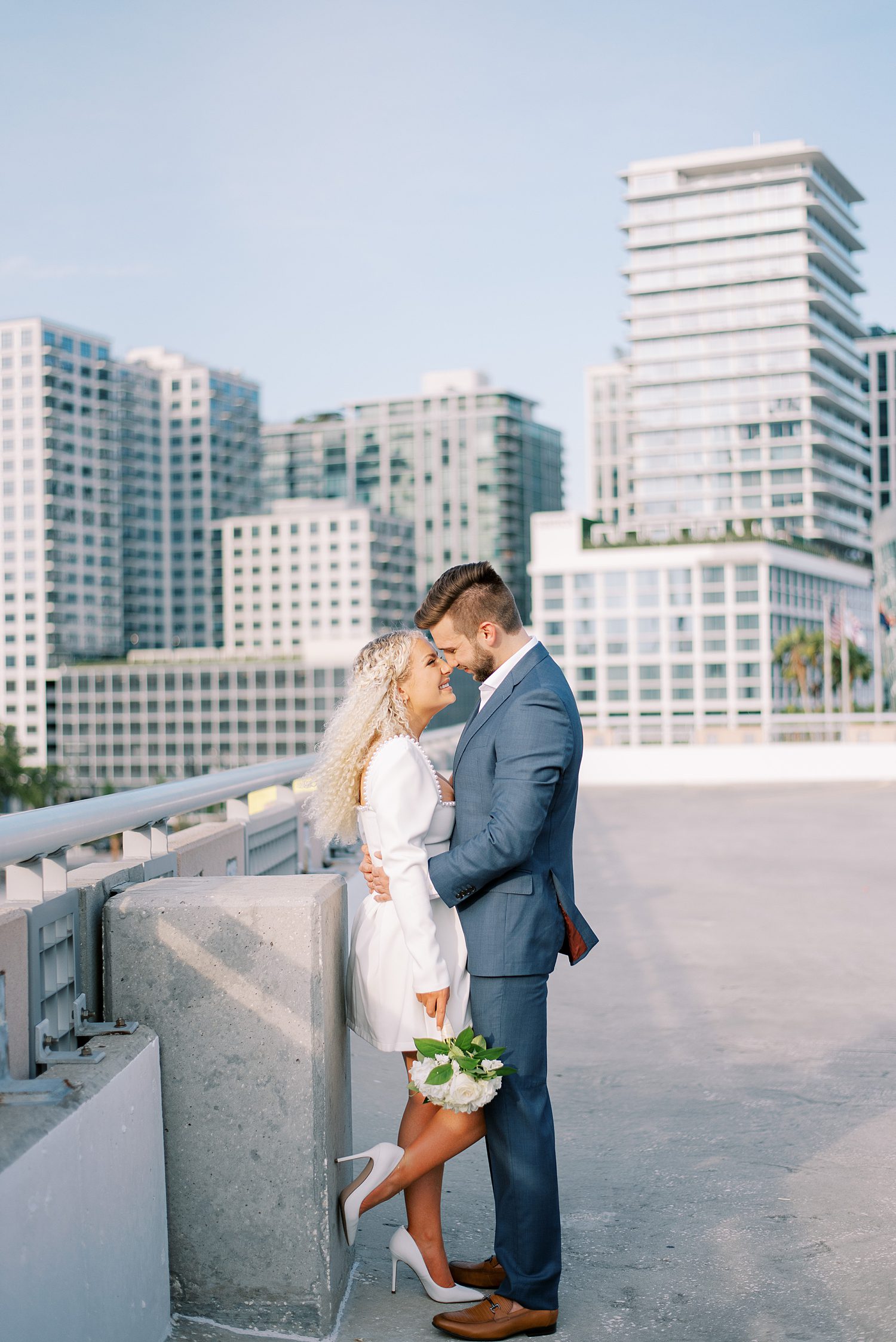 bride and groom hug during stylish downtown Tampa rooftop engagement session