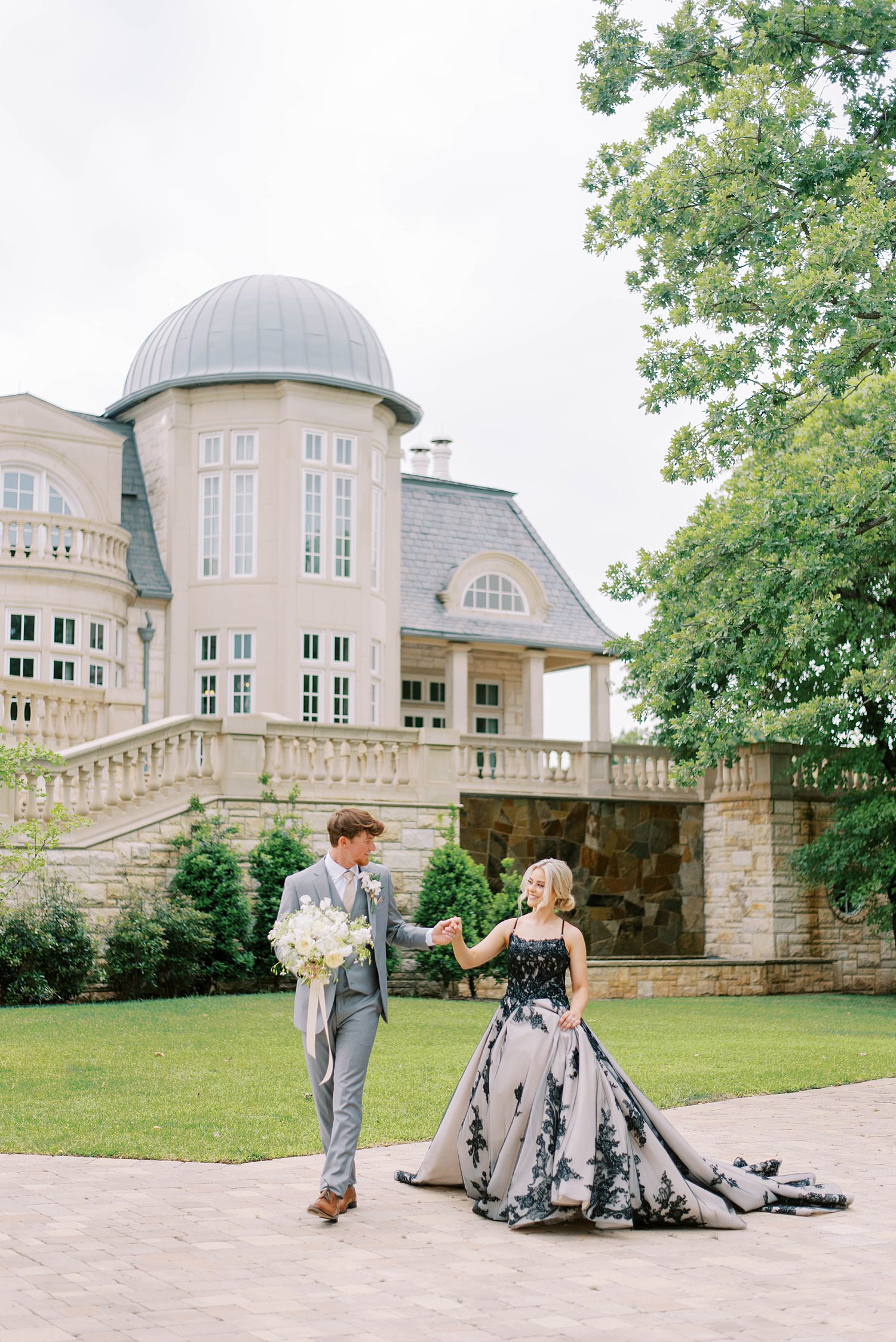 couple walks outside the Olana with bride in black dress