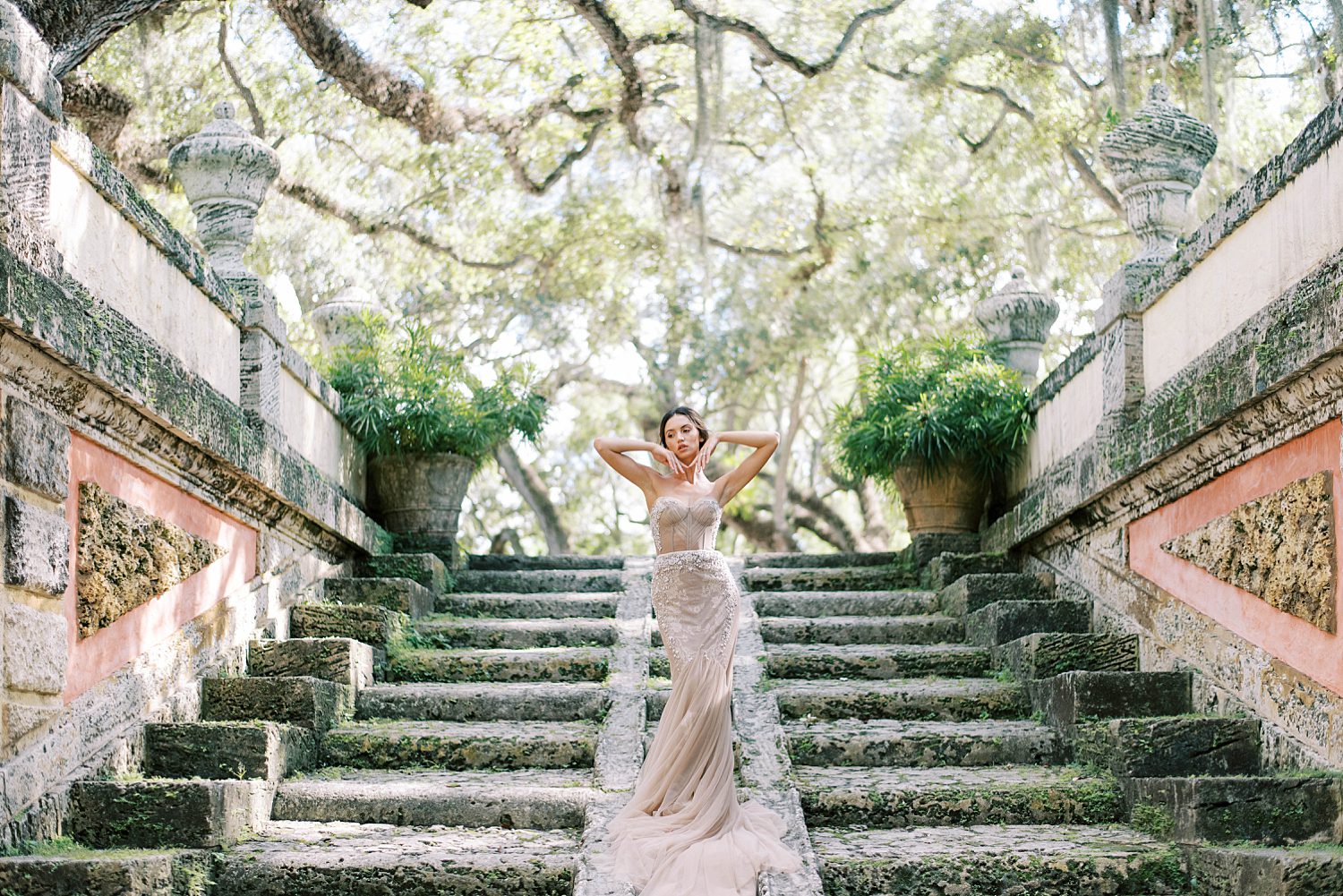 bride poses on stone steps at Vizcaya Museum