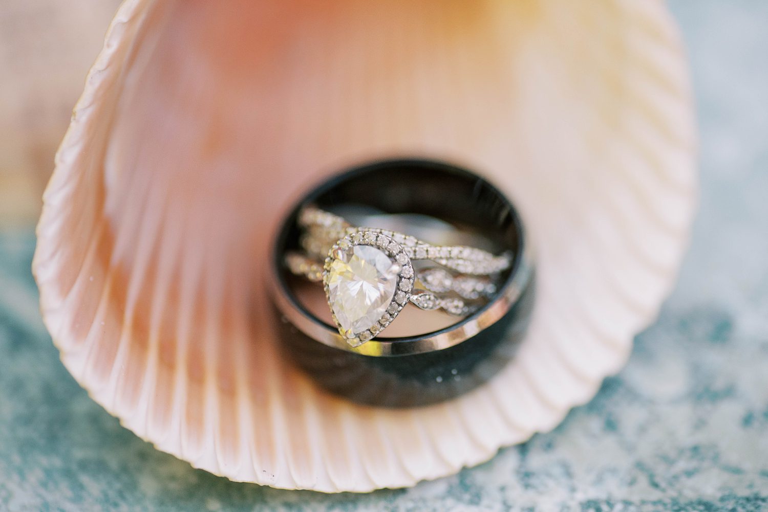 wedding rings lay stacked inside seashell before Florida beach wedding 