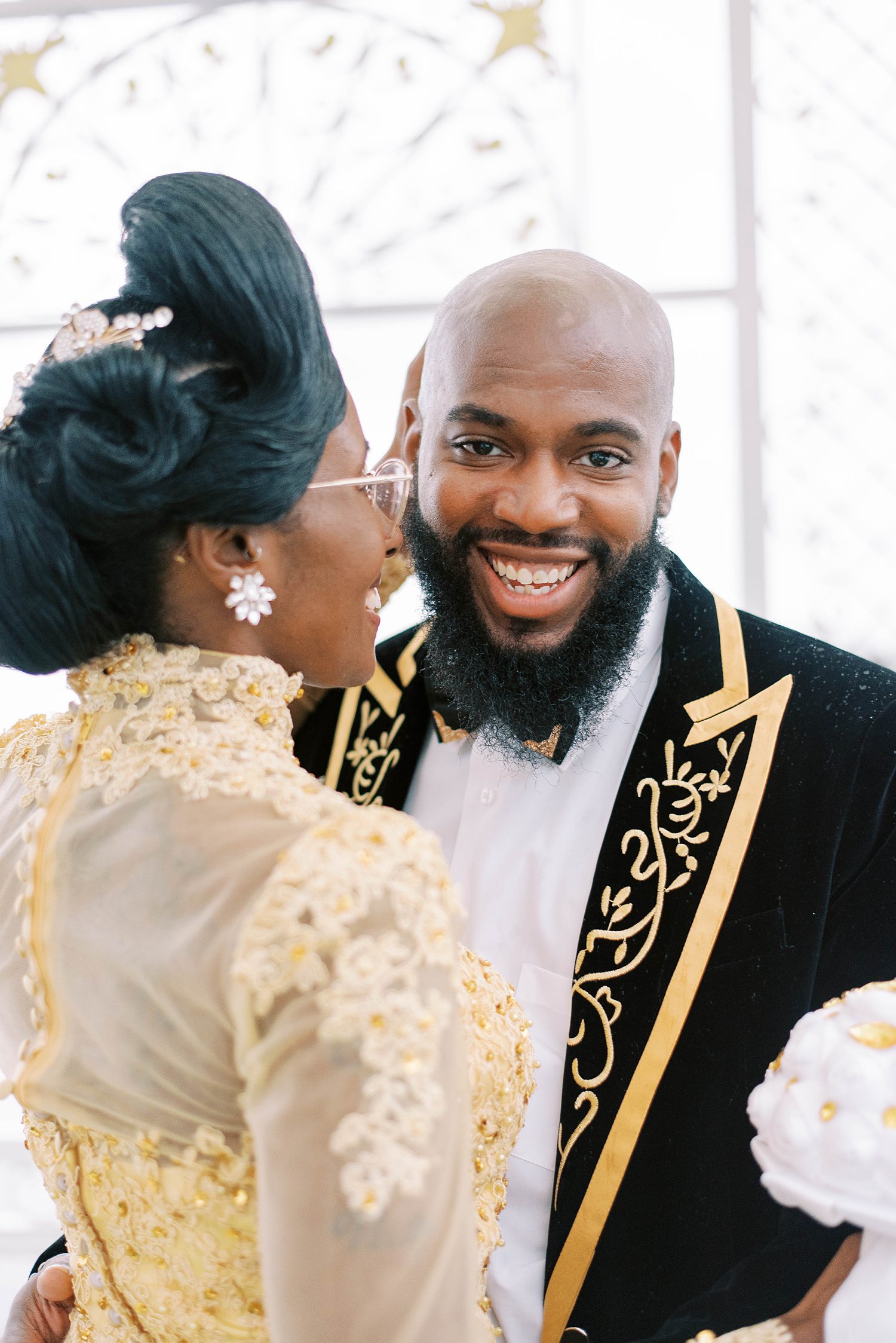 black woman in gold dress laughs with black man in gold and black suit at Chic Venue Golden Palace