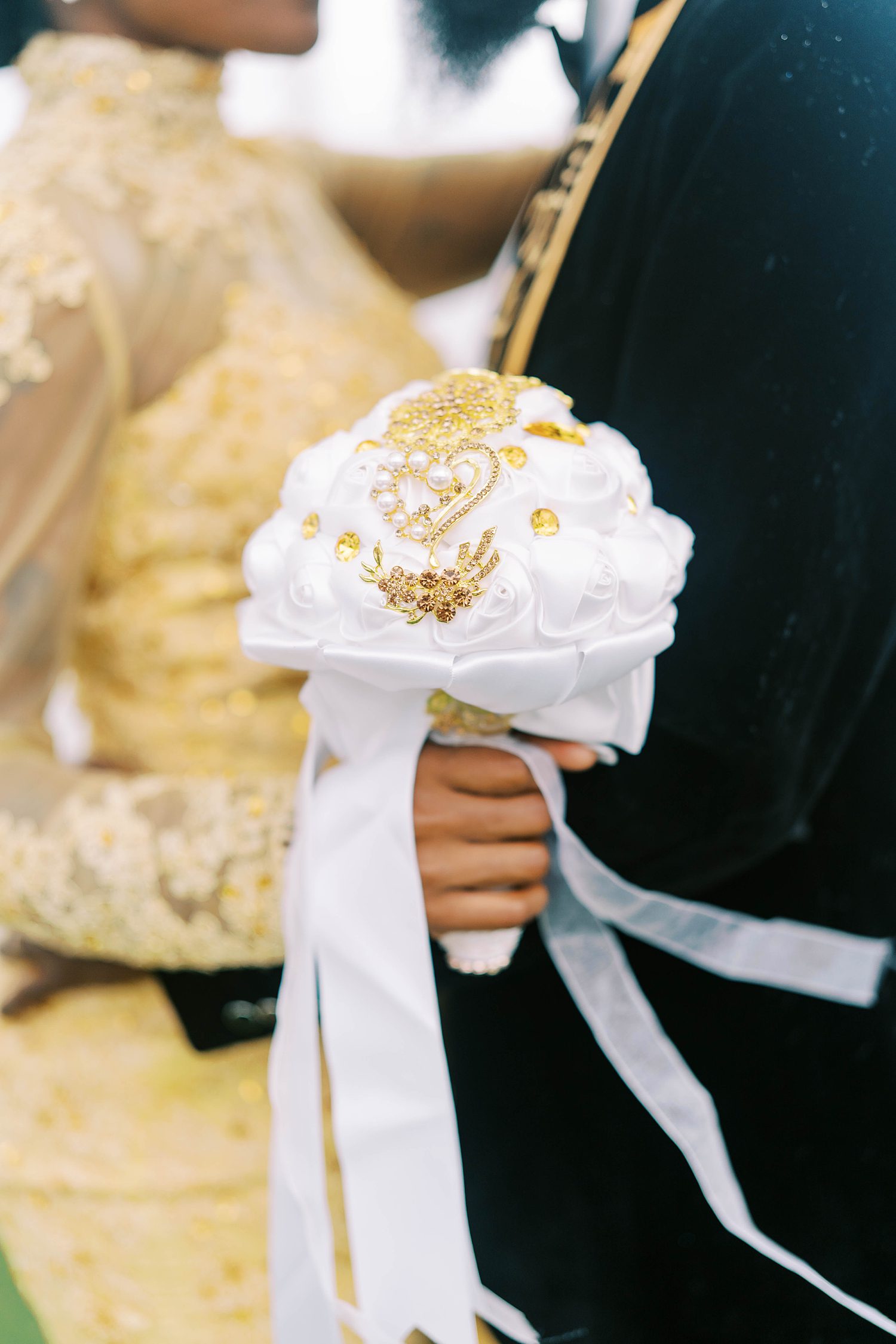 bride holds bouquet of white and gold flowers