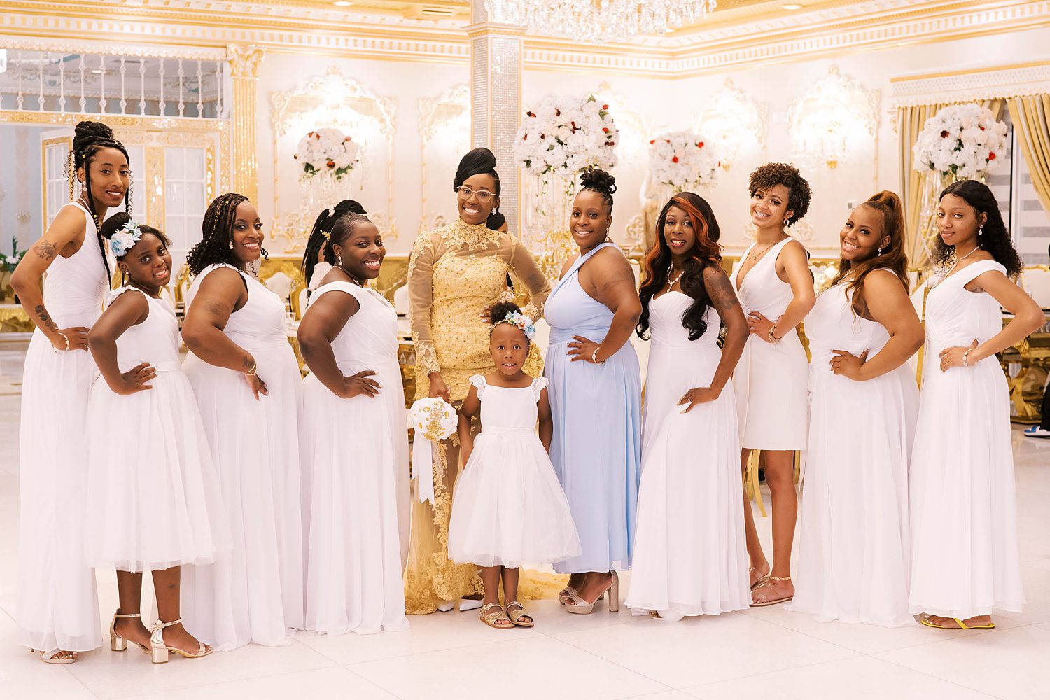 bride poses with bridesmaids in white gowns and maid of honor in blue gown