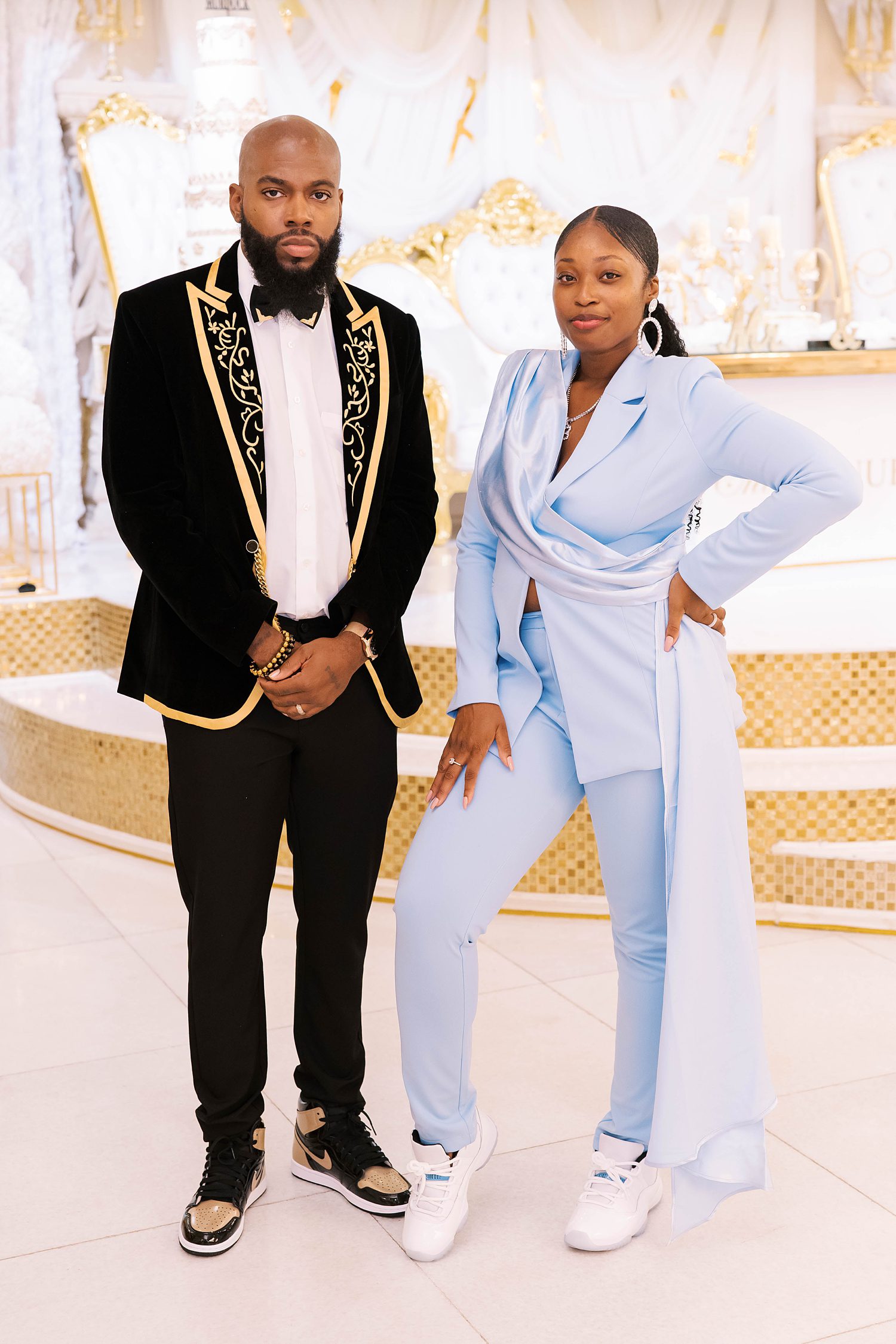 groom poses with bridesmaid in blue pantsuit 