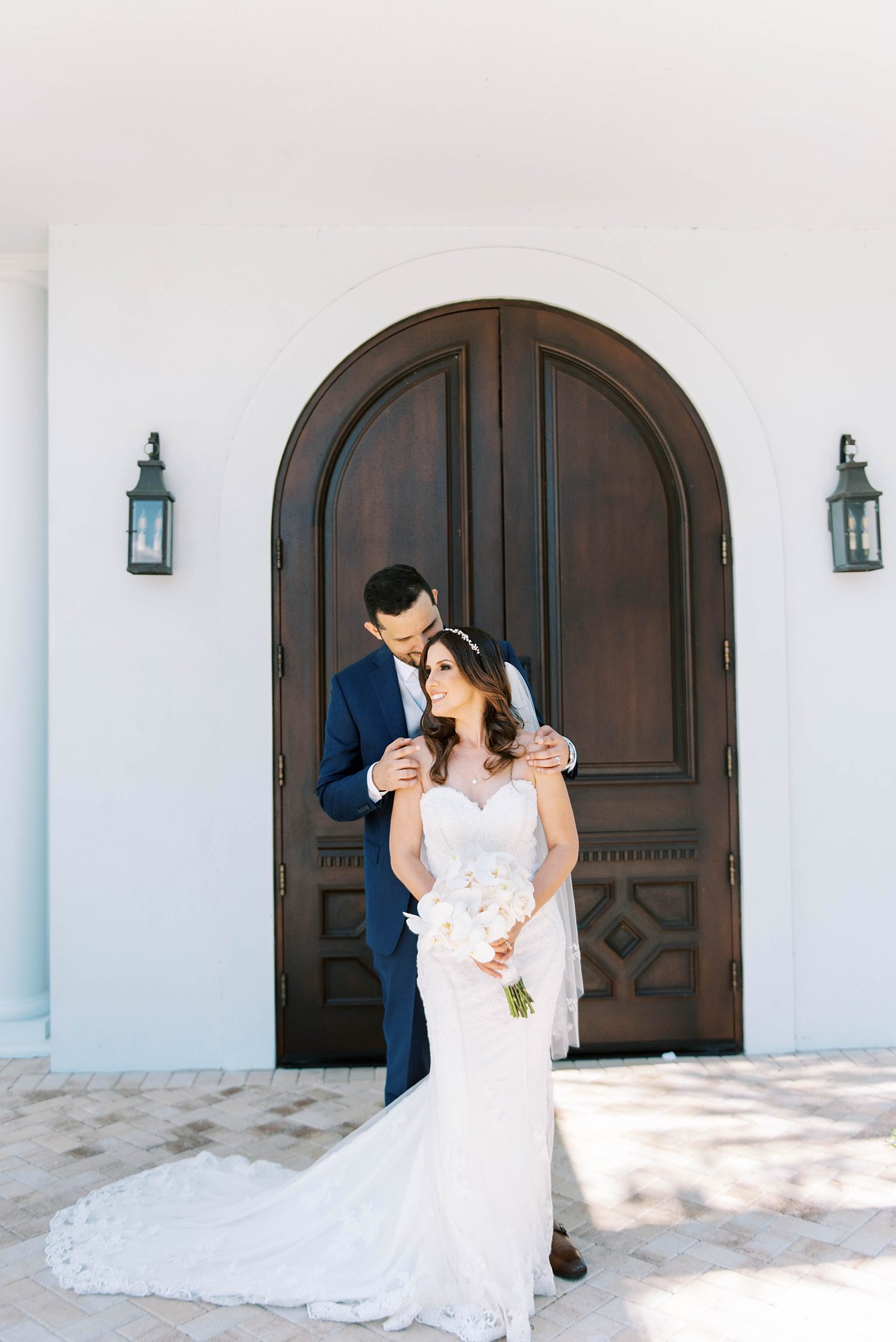 bride and groom hug by wooden door at Harborside Chapel