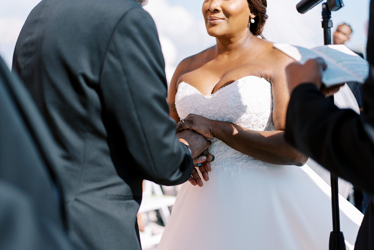 bride and groom hold hands during wedding ceremony on Tampa hotel balcony