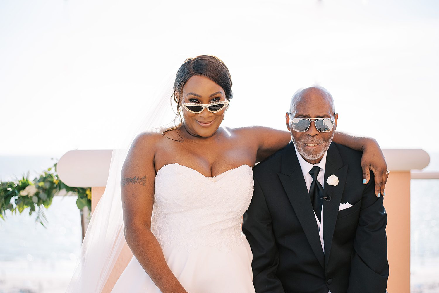 bride and groom hug showing off sunglasses during Tampa wedding photos
