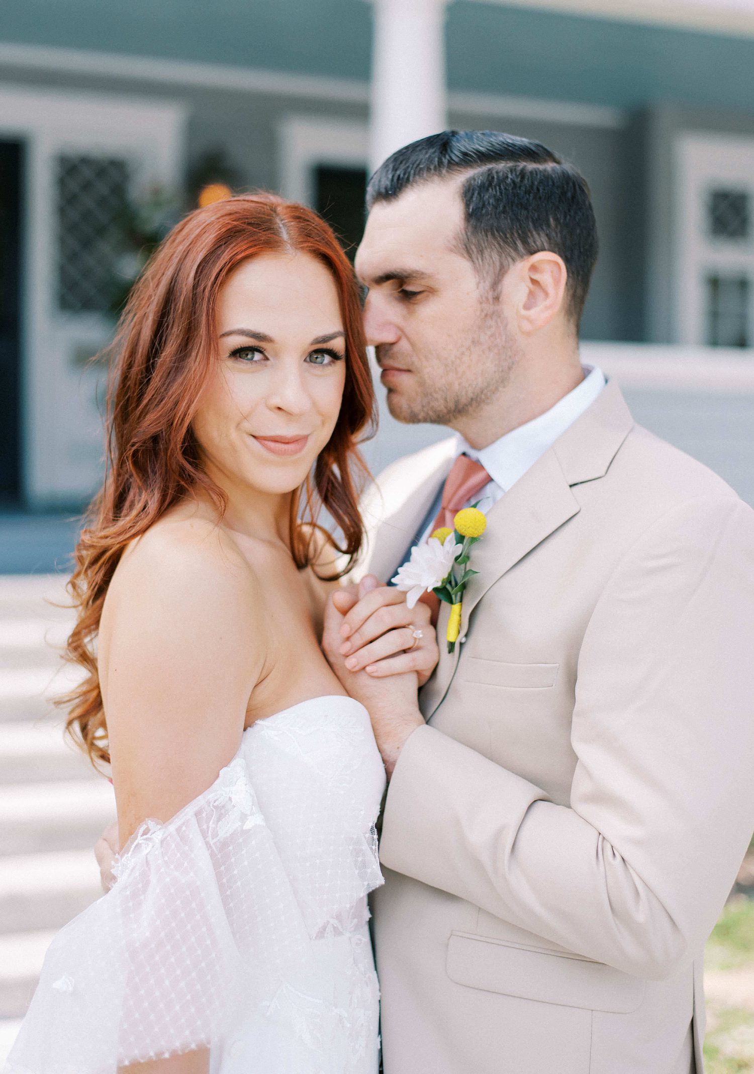 groom in tan suit leans into bride's cheek at The Orlo
