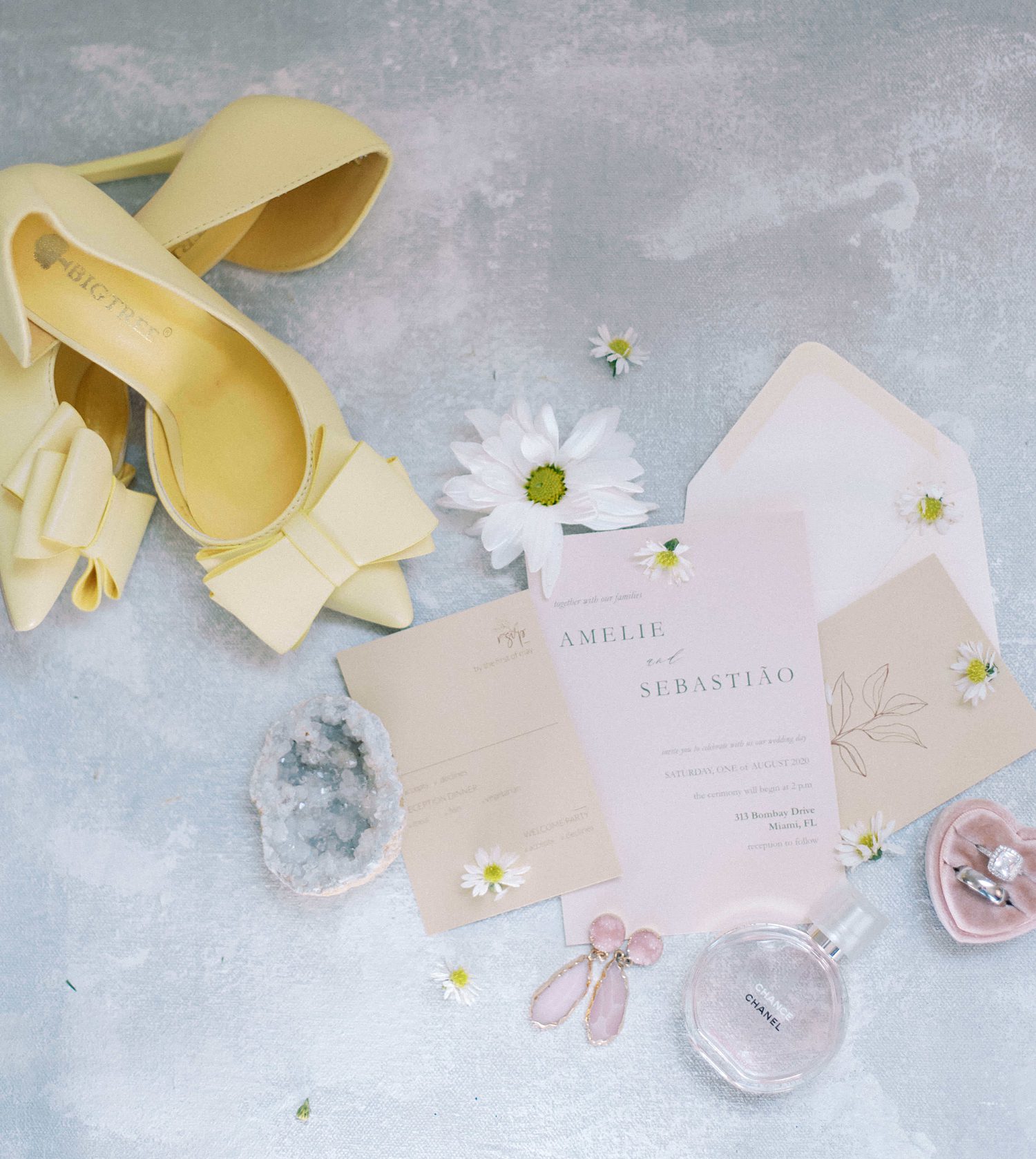yellow heels and daisies lay by pastel invitation suite for The Orlo wedding 