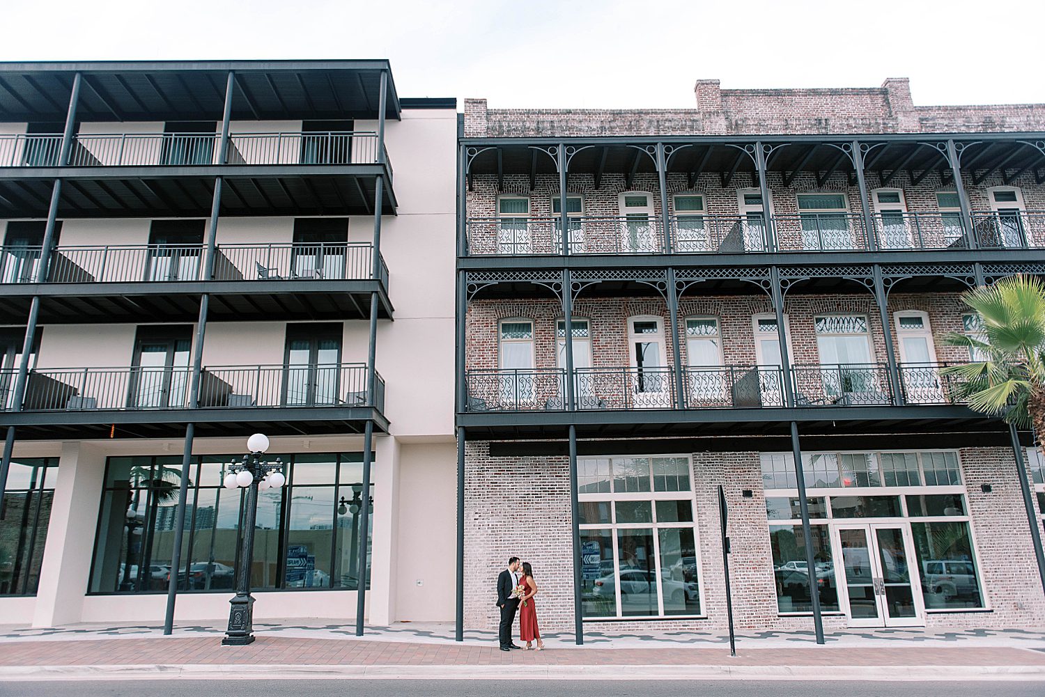 engaged couple hugs outside apartment building in Ybor City