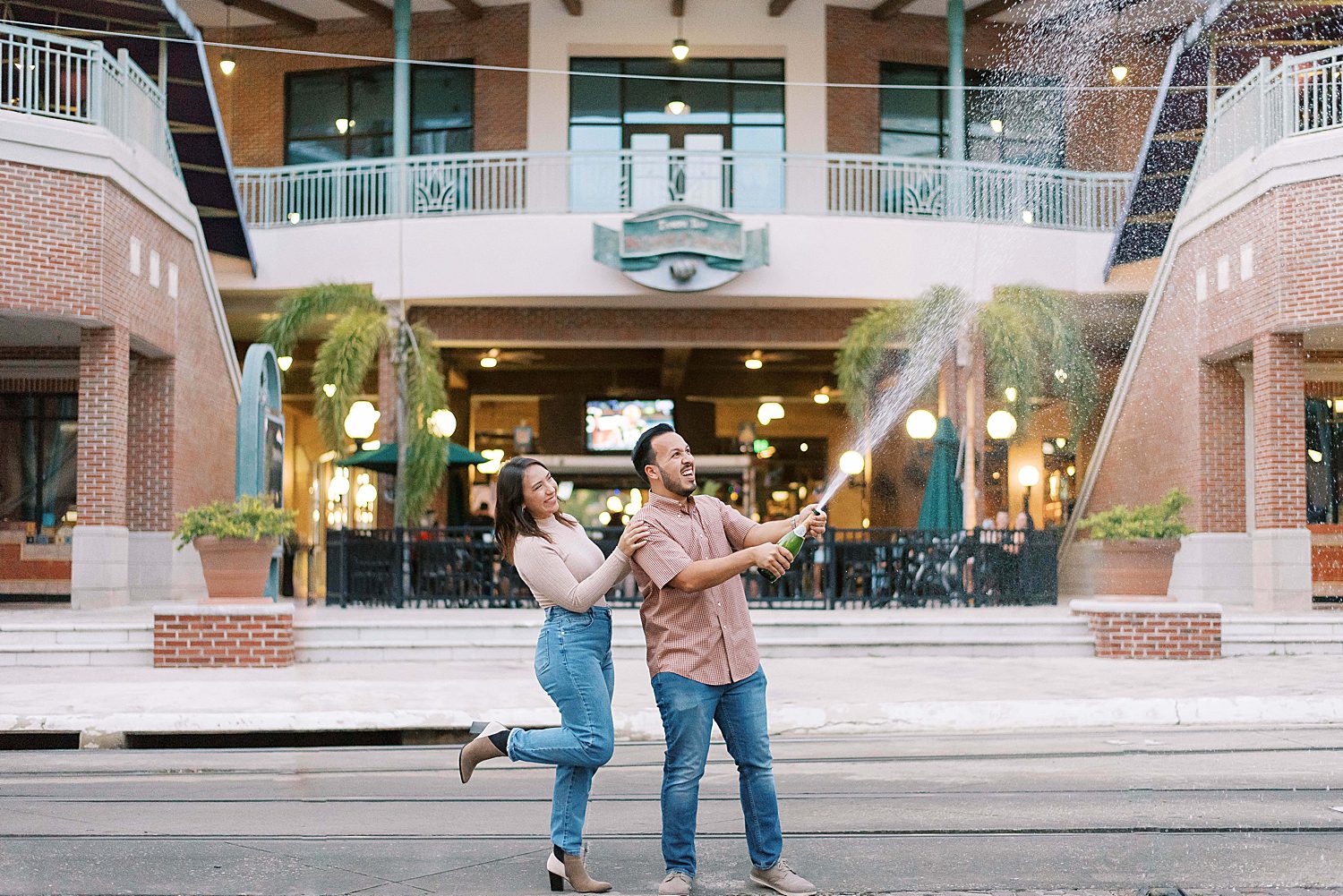 groom pops champagne for bride outside Ybor City shops