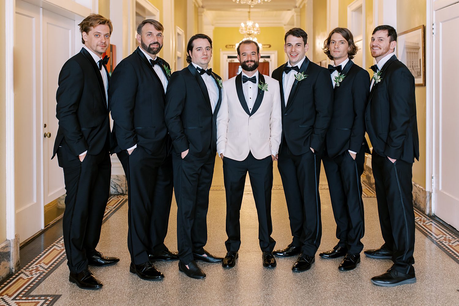 groom stands with groomsmen in black suits at Centro Asturiano de Tampa