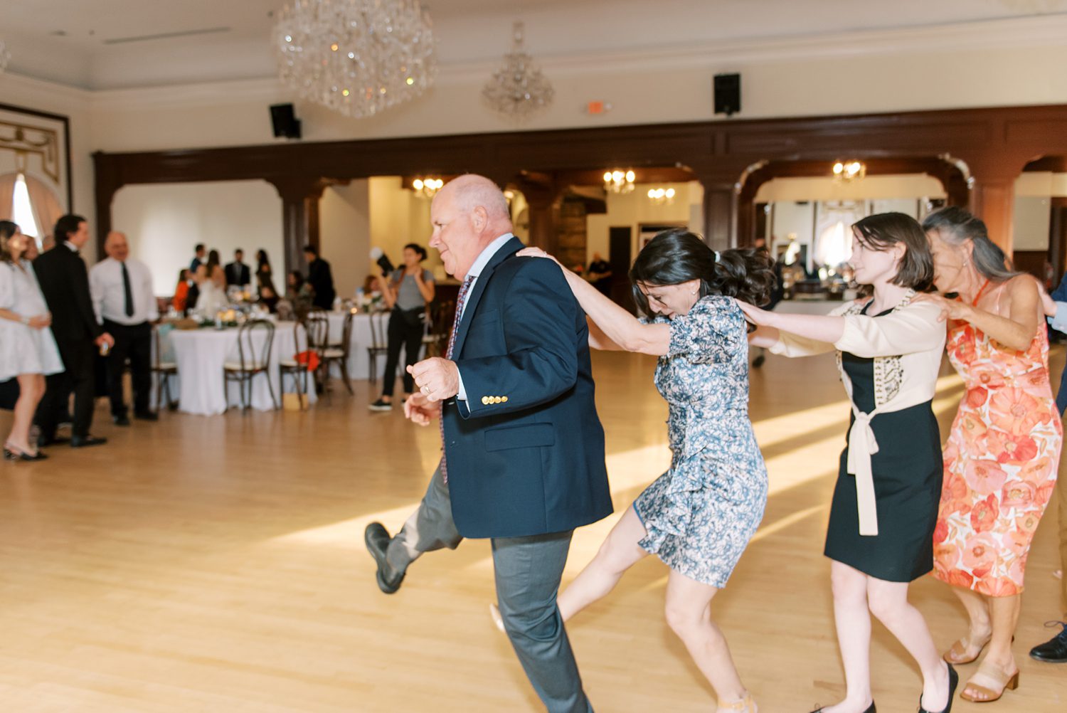 guests dance in conga line during FL wedding reception
