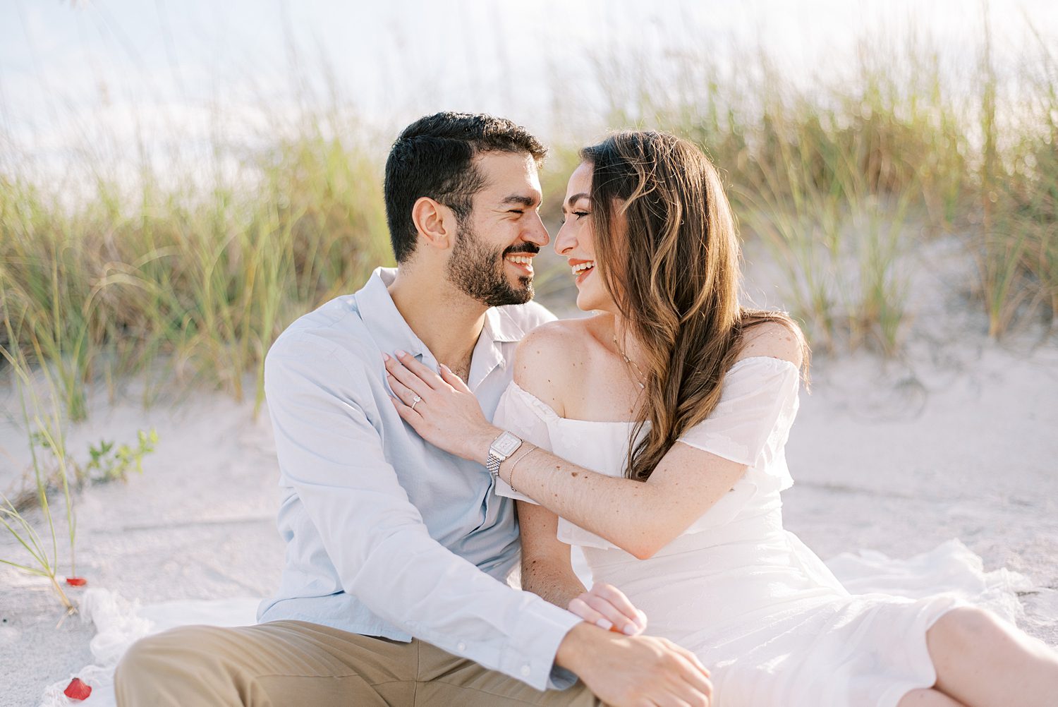 couple sits on dune at Fort DeSoto beach in Tampa FL