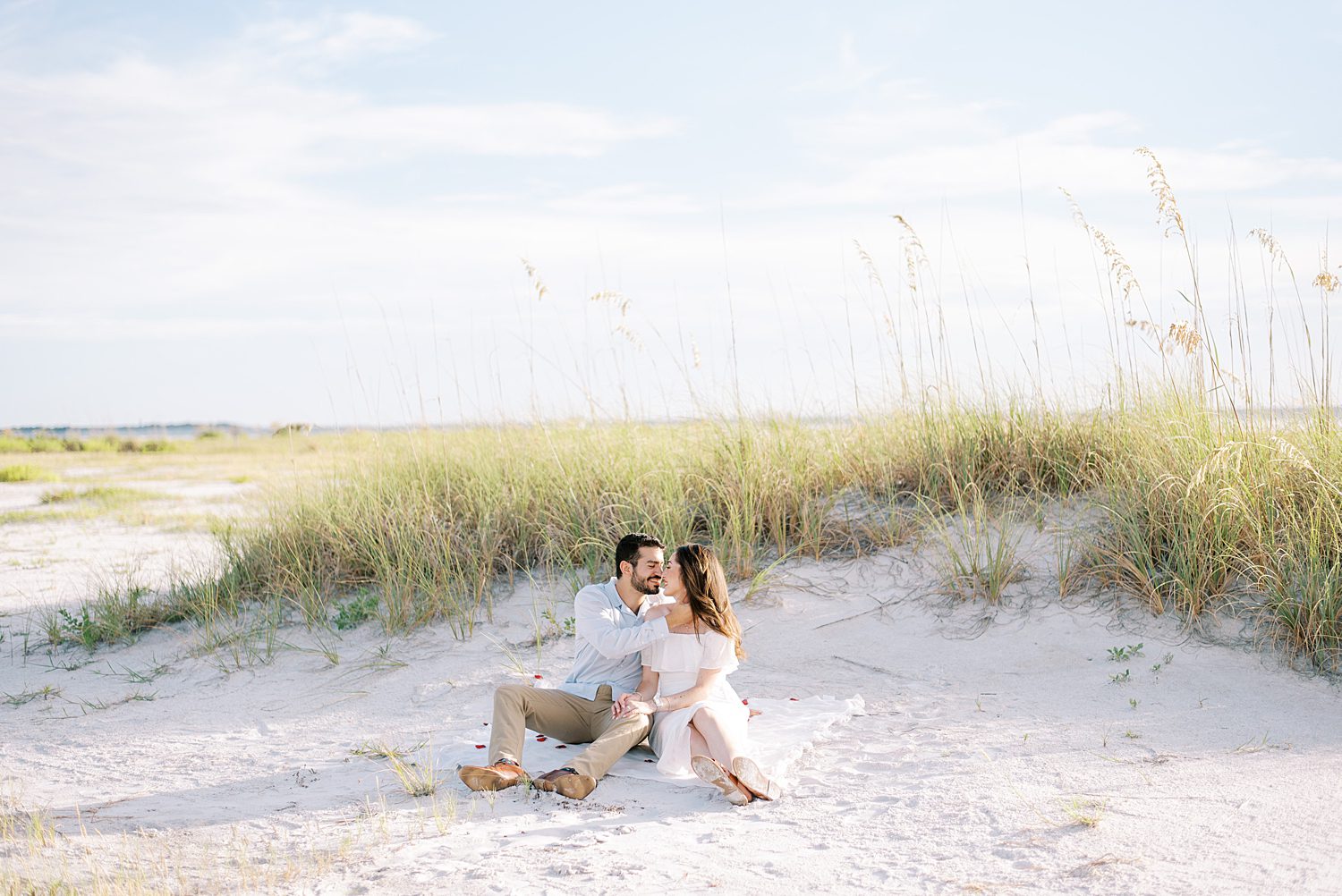 engaged couple kisses on dune at Fort De Soto beach