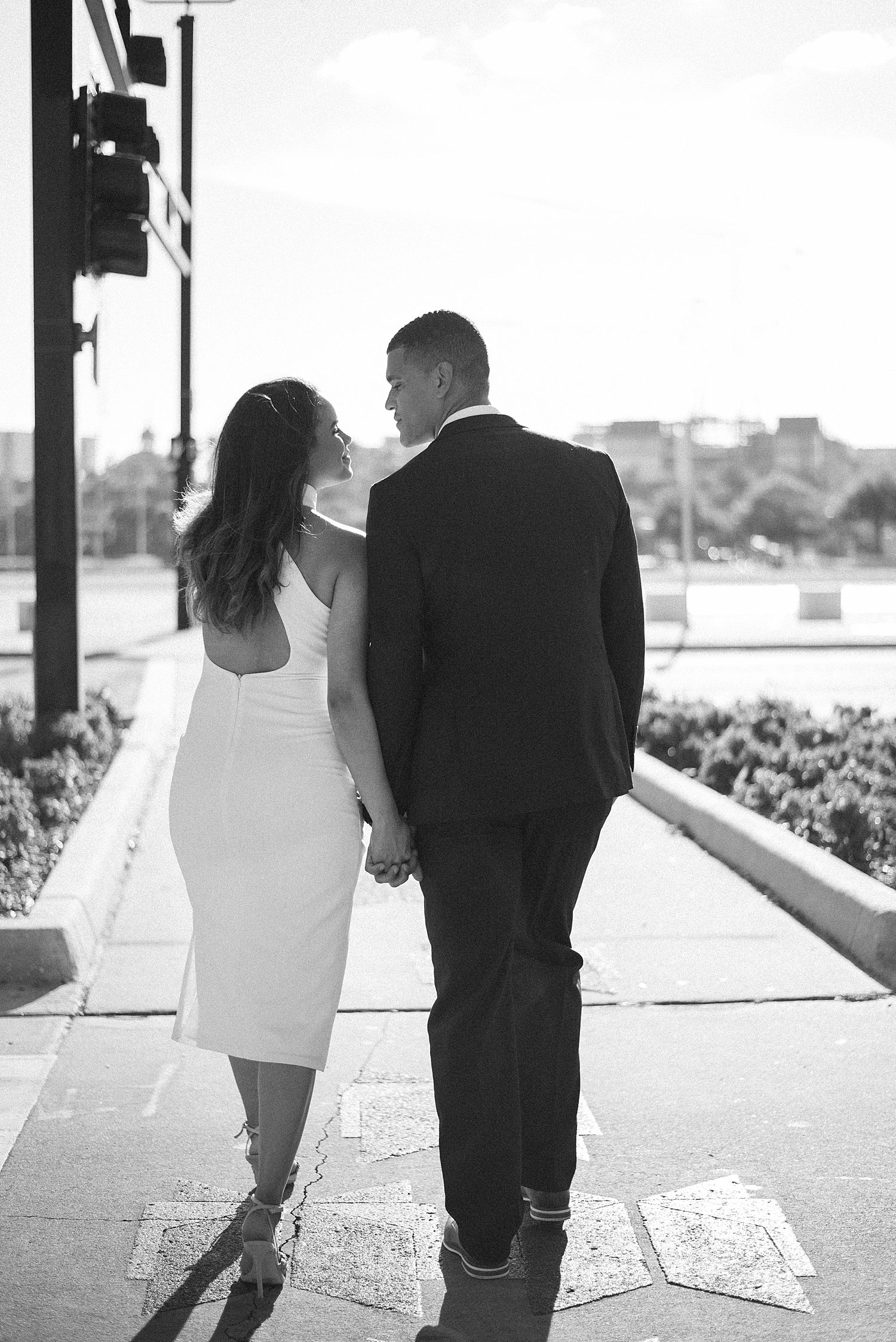 couple holds hands walking on sidewalk in Downtown Tampa FL