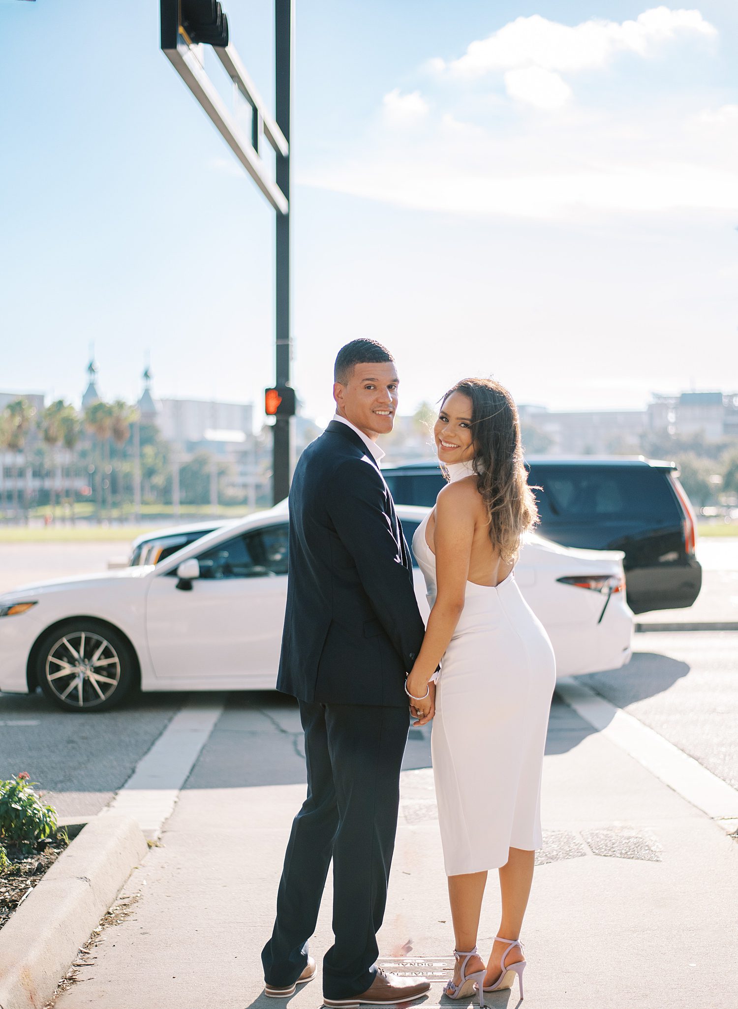 engaged couple walks towards white car in Tampa FL