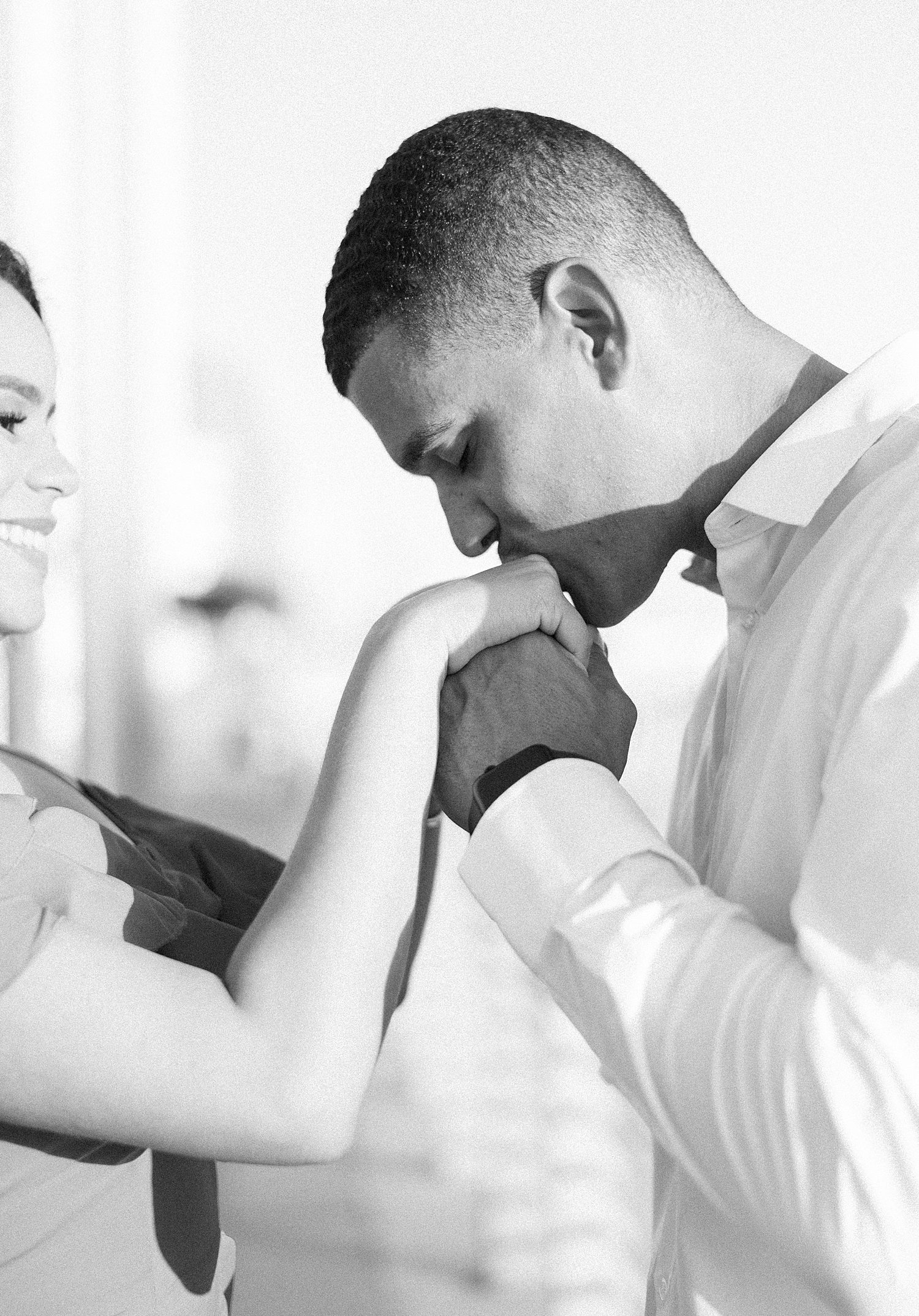 man kisses fiancee's hand during FL engagement photos