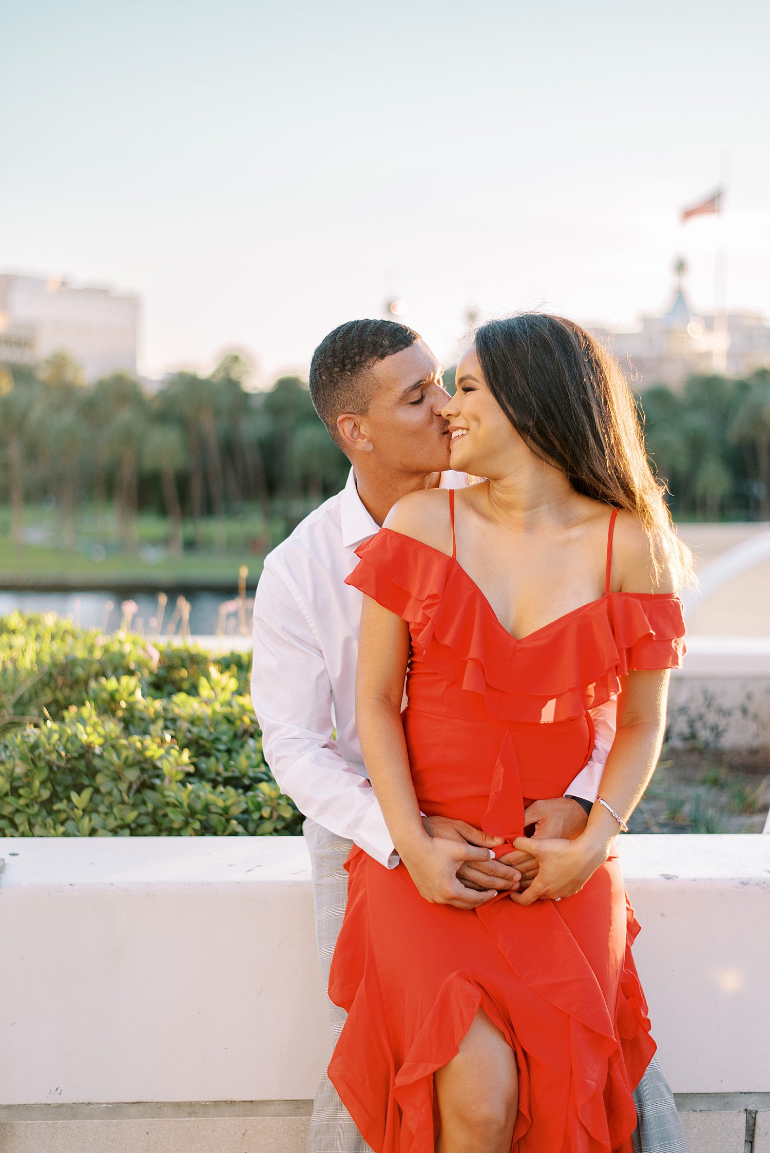 man kisses woman from behind on edge of garden in Curtis Hixon Park